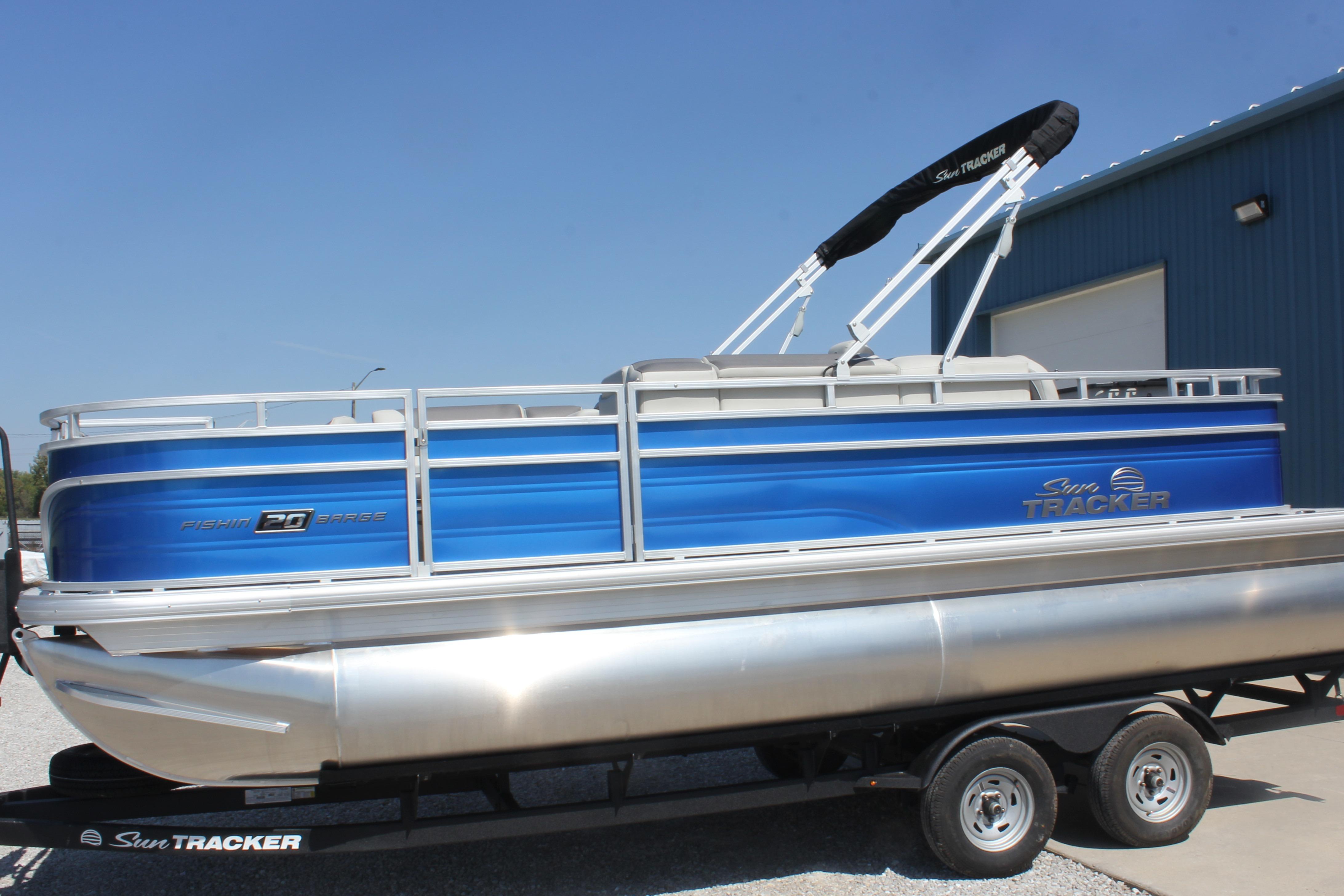 2026 Sun Tracker Fishin' Barge 20 DLX pontoon boat on trailer, blue exterior.