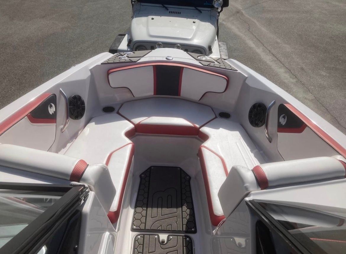 The image shows the interior of a 2017 Scarab 215 boat with white and red seating.