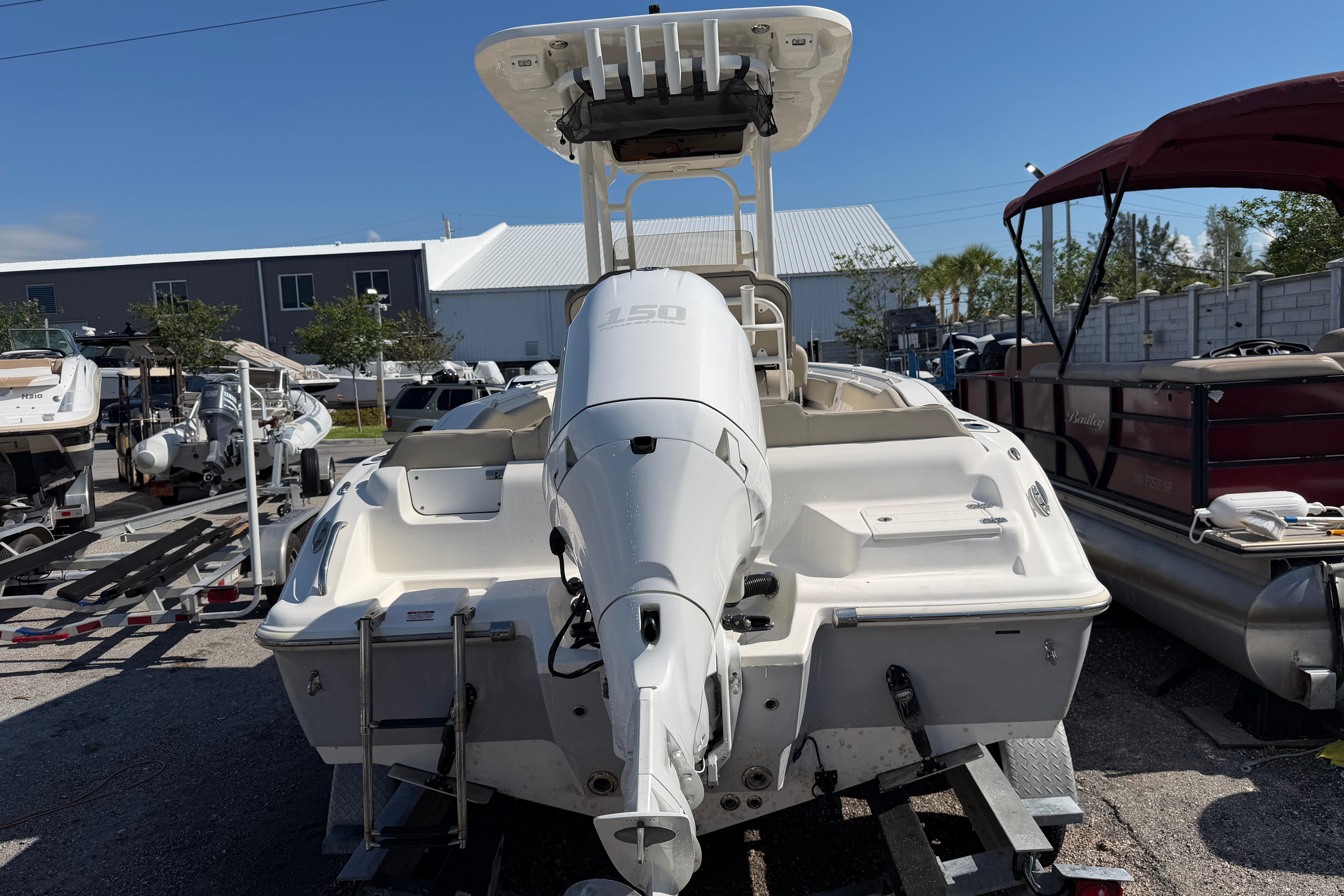 2022 Key West 219 FS boat with outboard motor, parked in a marina.