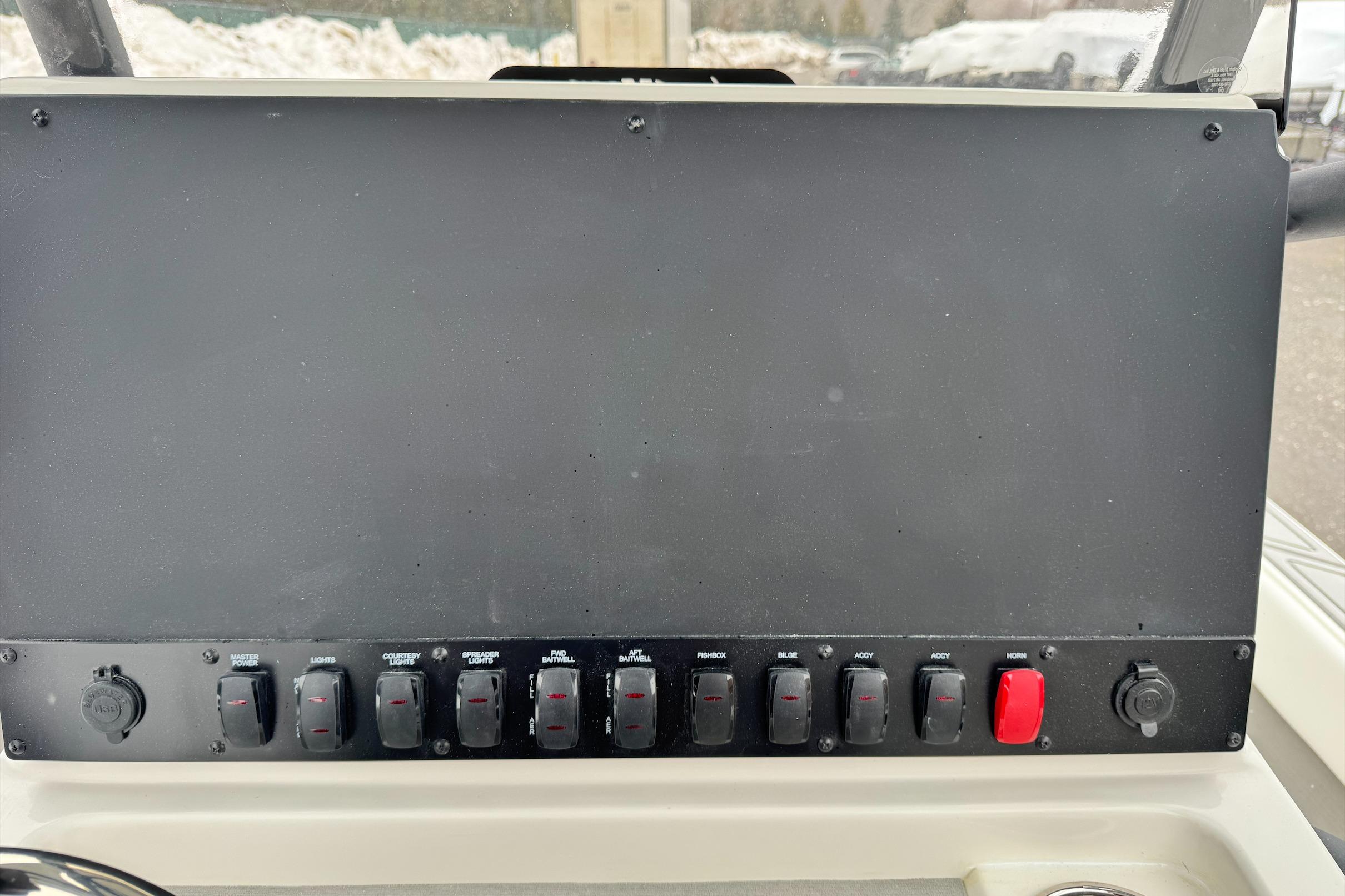 Control panel of 2026 Mako 24 APEX boat with switches and buttons.