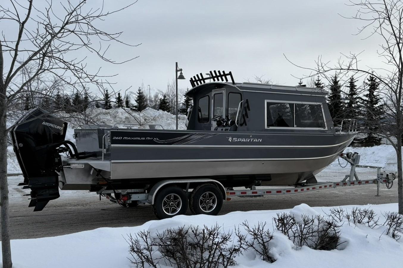 2024 Spartan 26 Maximus Pro XL boat on trailer in snowy landscape.