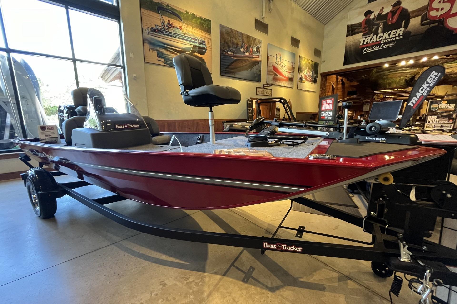 2026 Tracker Bass Tracker Classic XL boat displayed in showroom, featuring sleek red design.