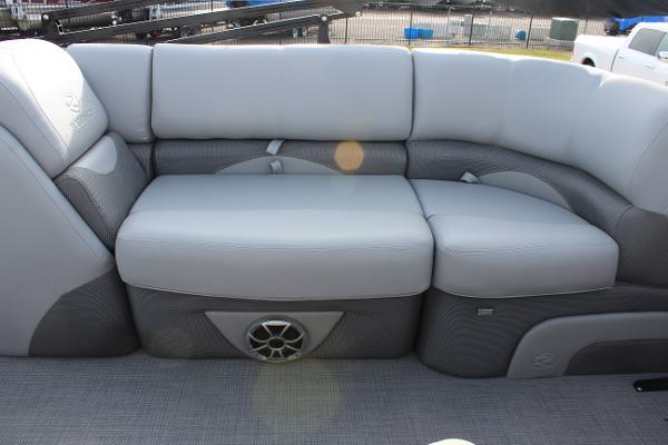 2025 Regency 230 DL3 boat interior with gray cushioned seating and built-in speaker.