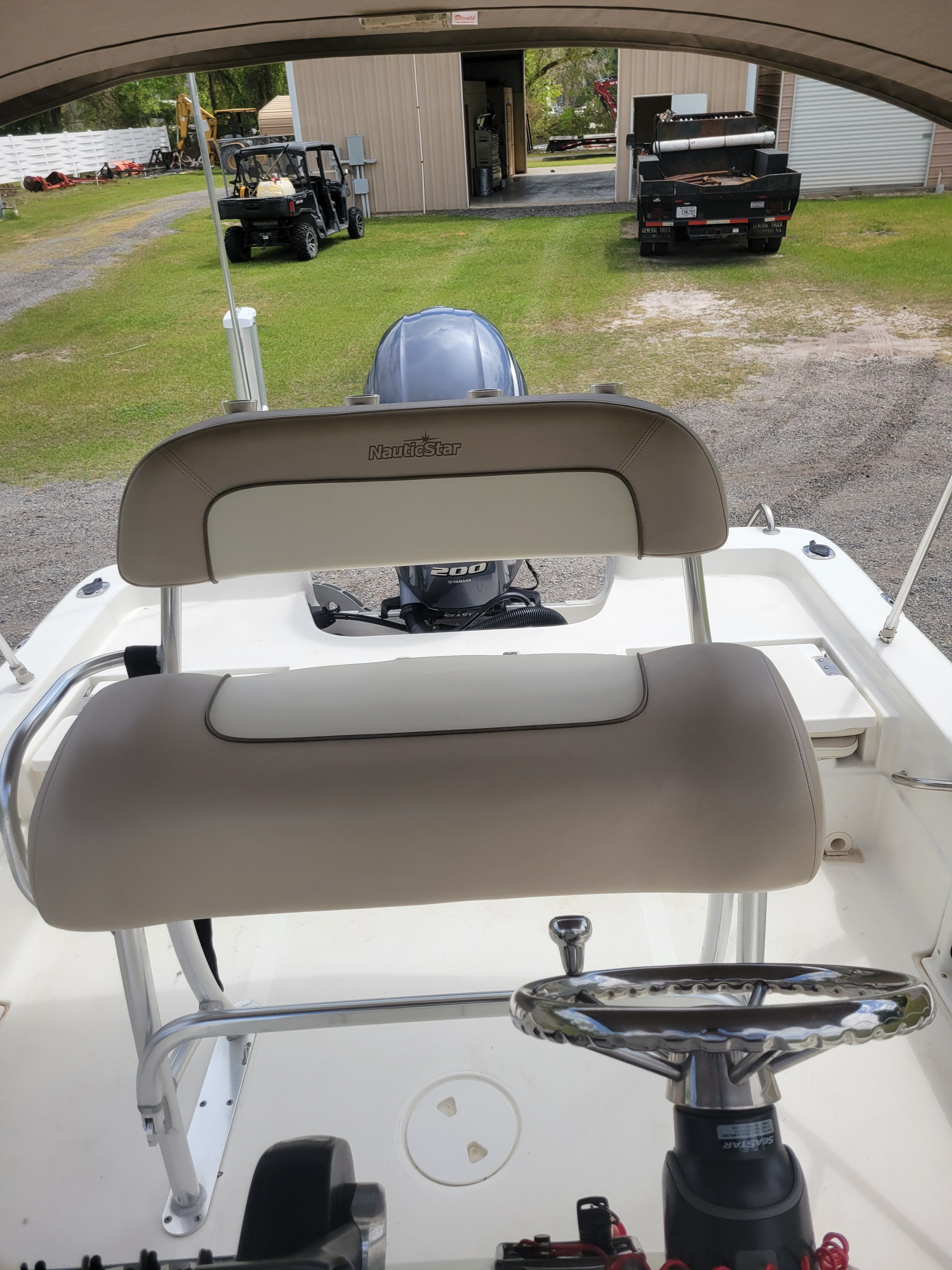 The image shows the cockpit of a NauticStar 2200 Sport boat with an outboard motor.