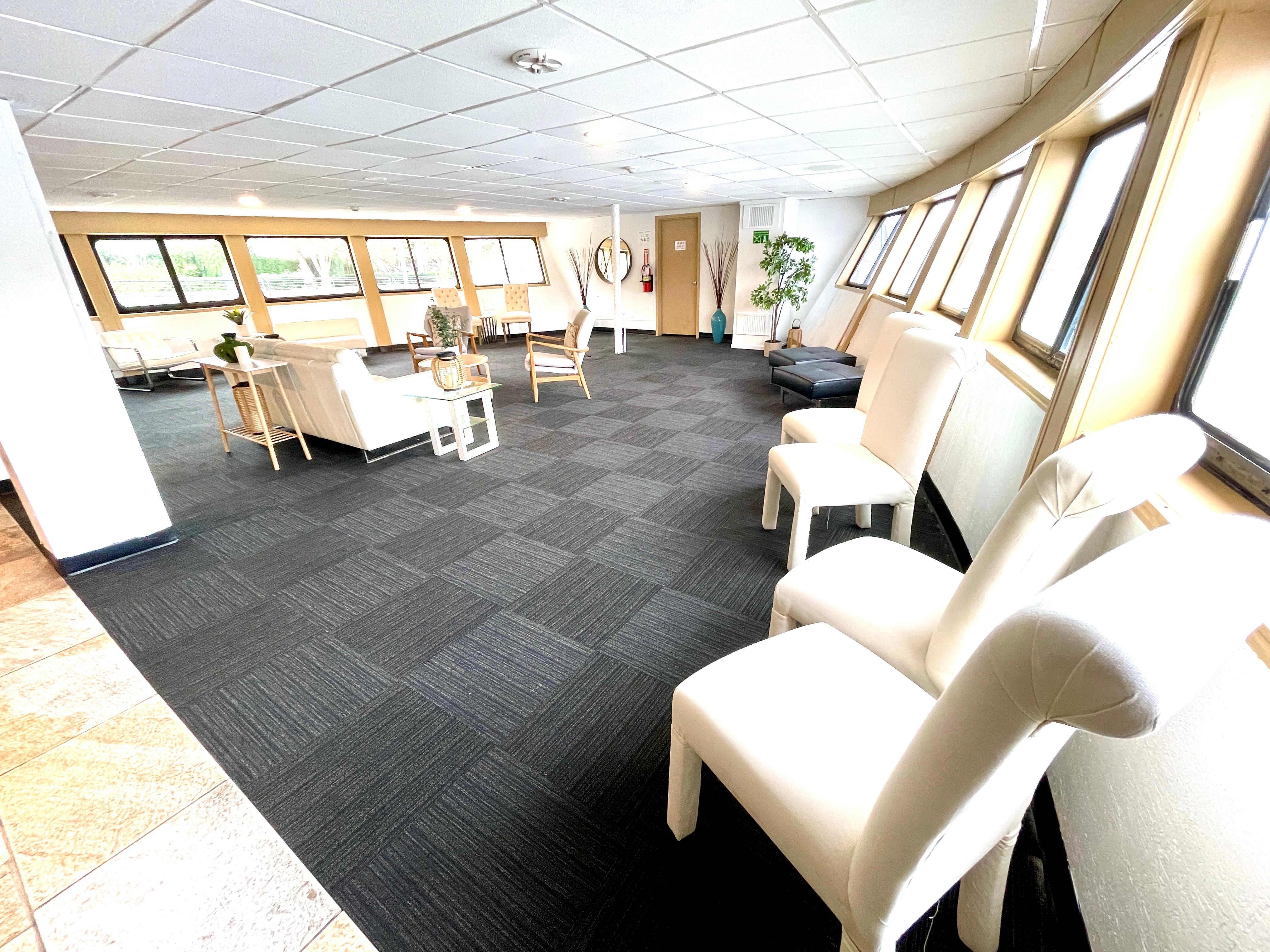 Spacious interior of 1983 Blount Custom Tri-Deck yacht with modern seating and large windows.