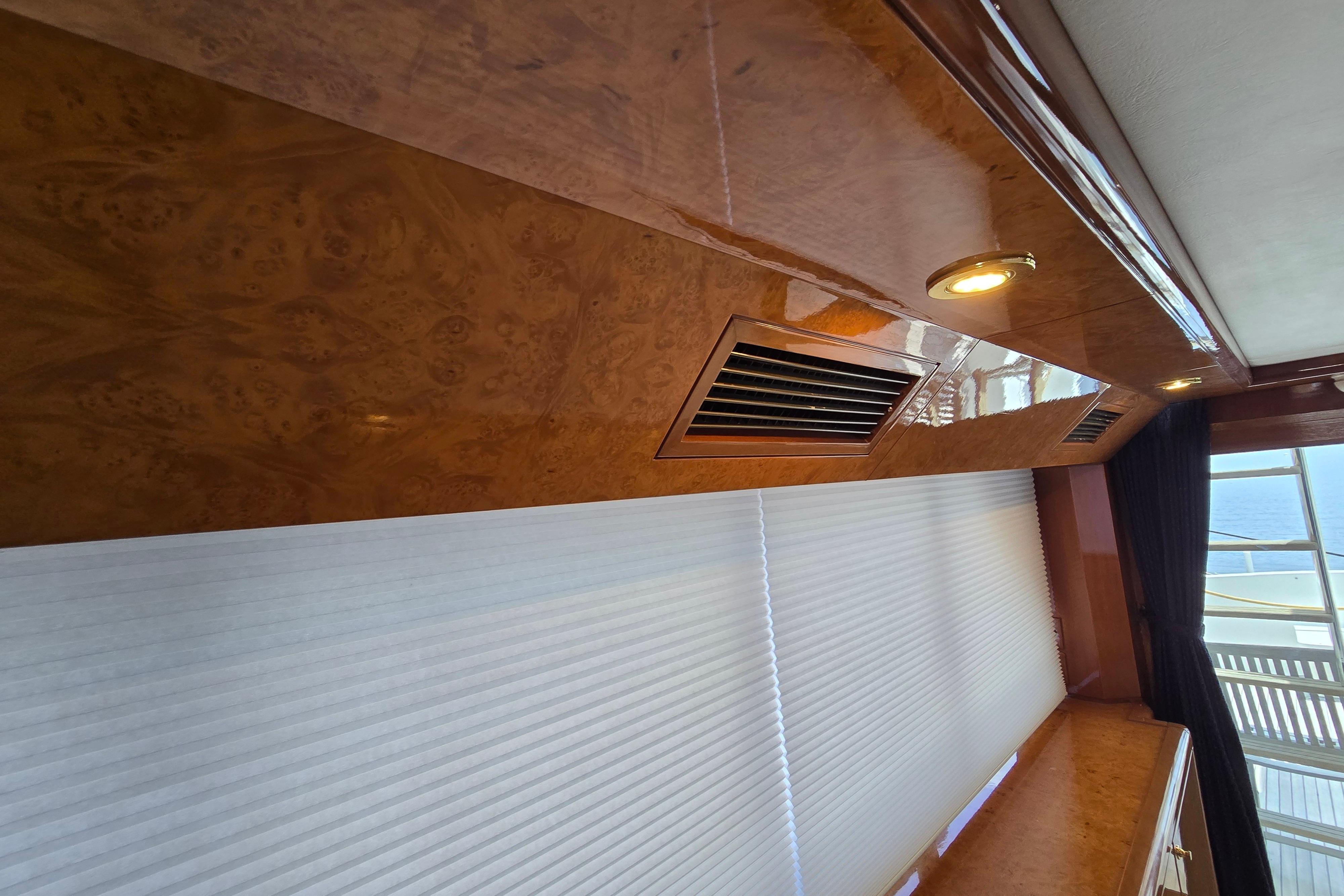 Luxurious wooden interior of 2004 Grand Harbour 58 yacht with elegant lighting and window blinds.