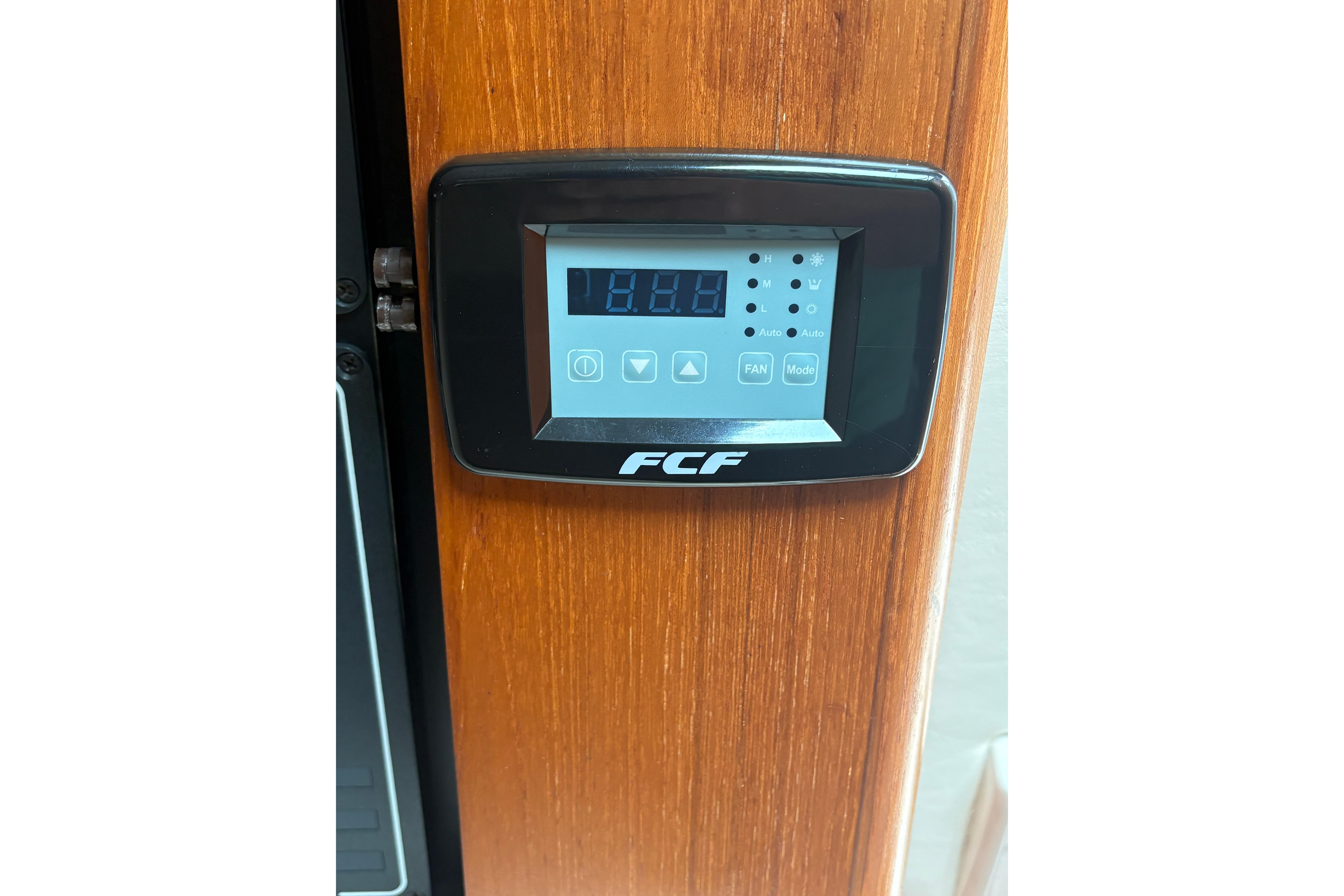 Digital control panel on 1999 Tiara Yachts 3100 Open, mounted on wooden surface.