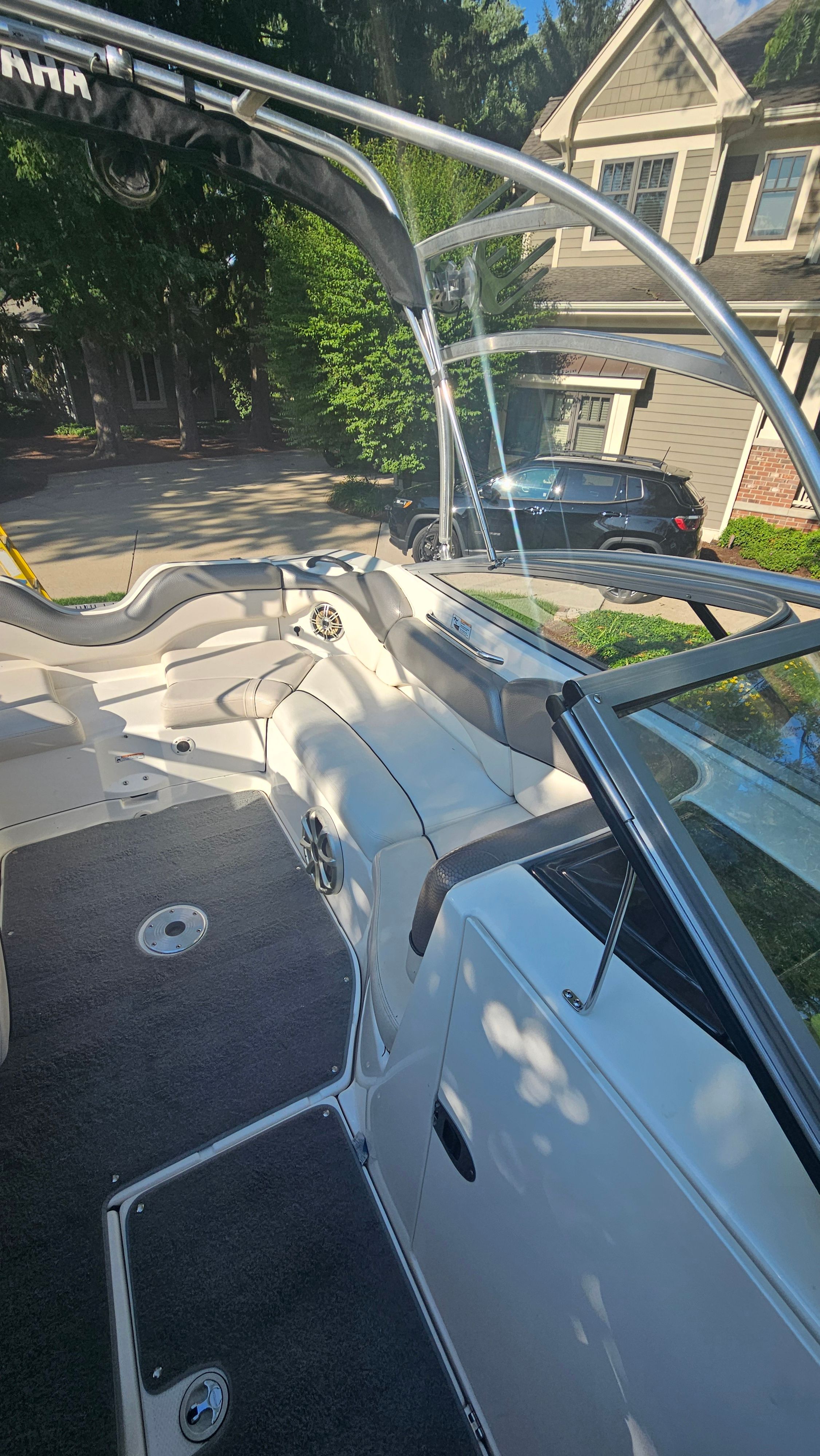 Interior view of a 2010 Yamaha AR210 boat with white seating and gray flooring.