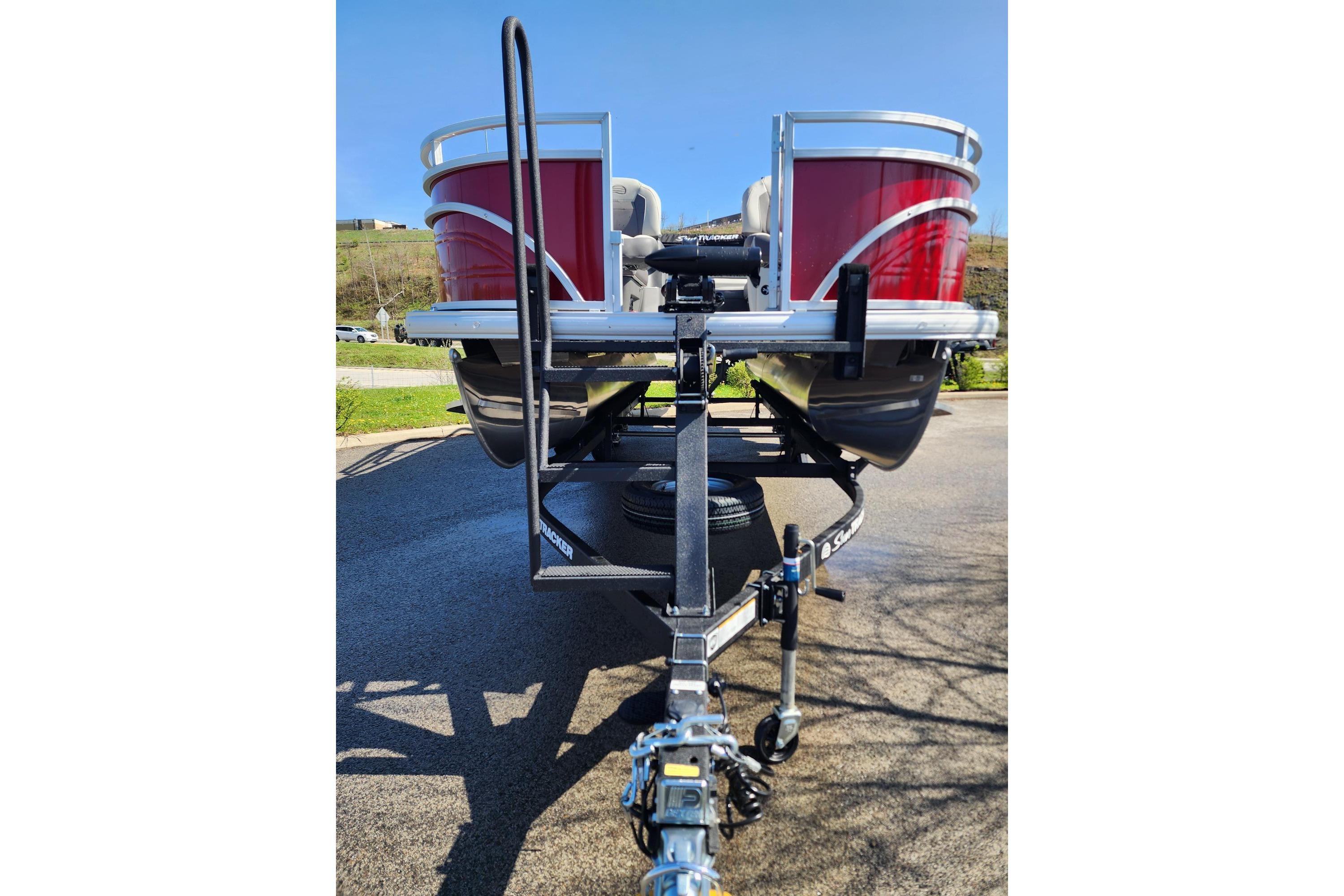 2026 Sun Tracker Fishin' Barge 22 DLX pontoon boat on trailer, front view.