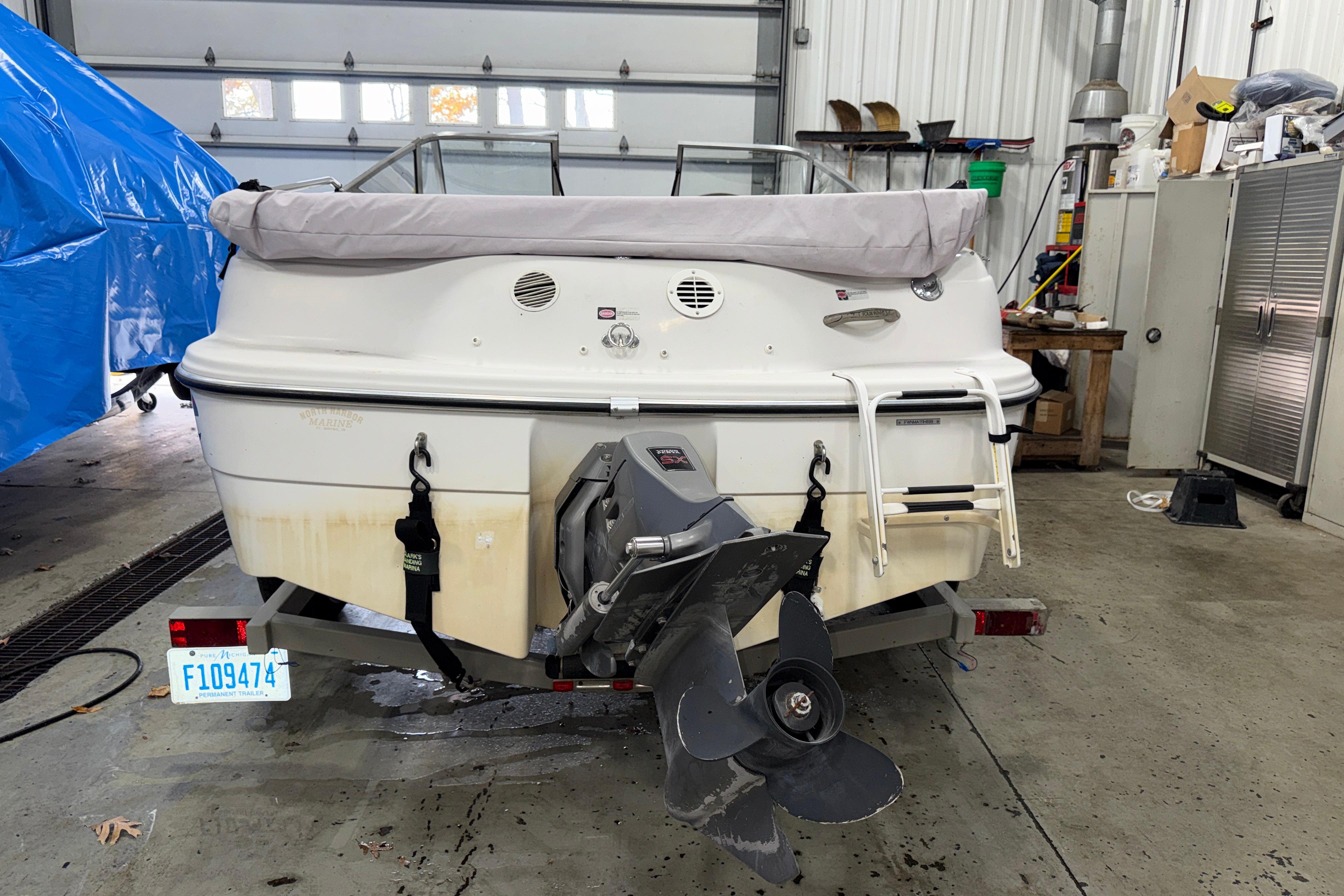 1999 Four Winns 170 Horizon LE boat in garage, rear view with propeller and ladder.