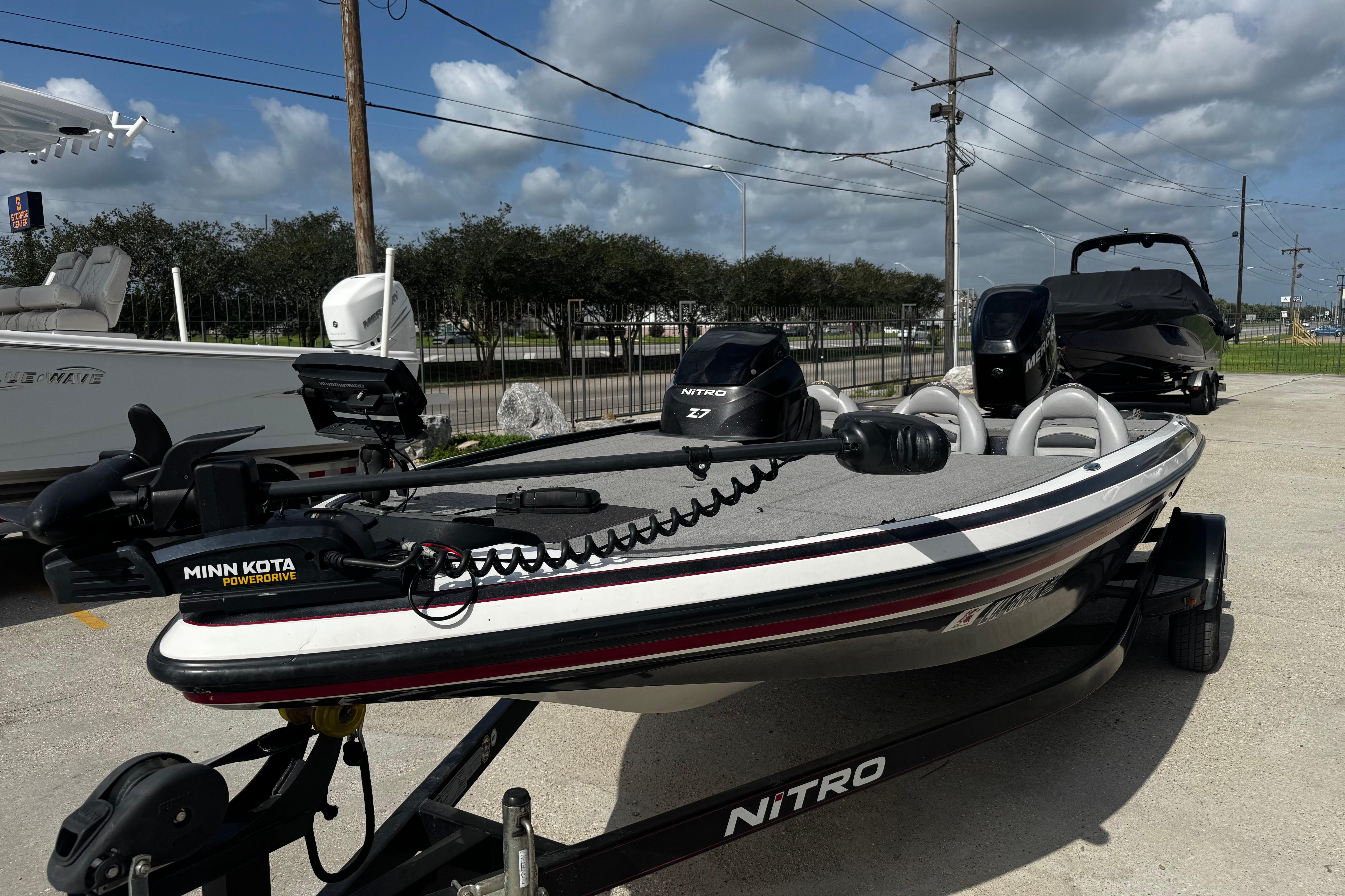 2012 Nitro Z-7 boat with Minn Kota PowerDrive, parked outdoors under a cloudy sky.