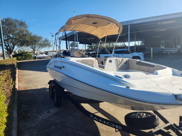 2025 Tahoe 1950 boat with canopy on trailer, parked outdoors.