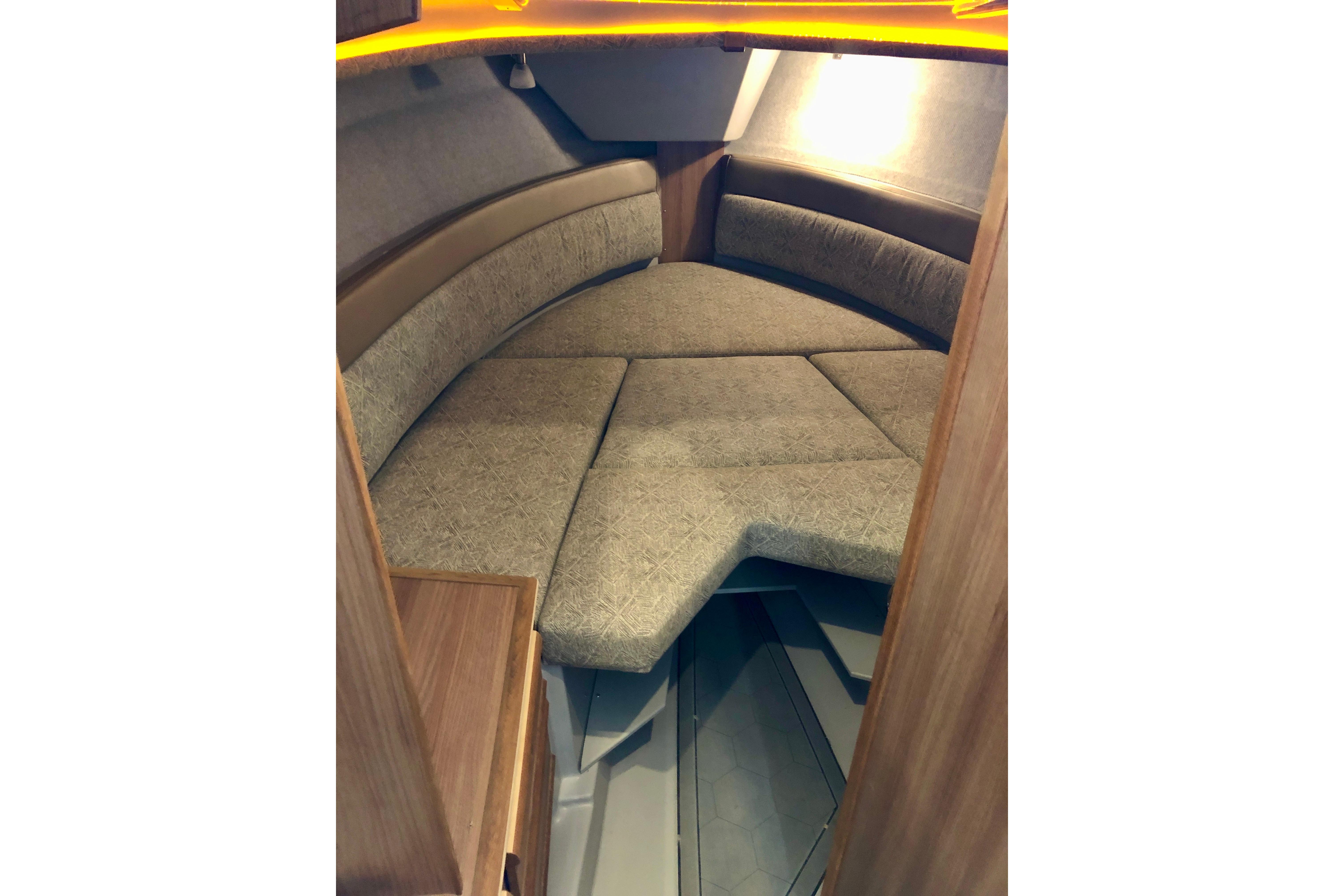 2024 Ranger Tugs R-27 interior cabin with cozy seating and warm lighting.
