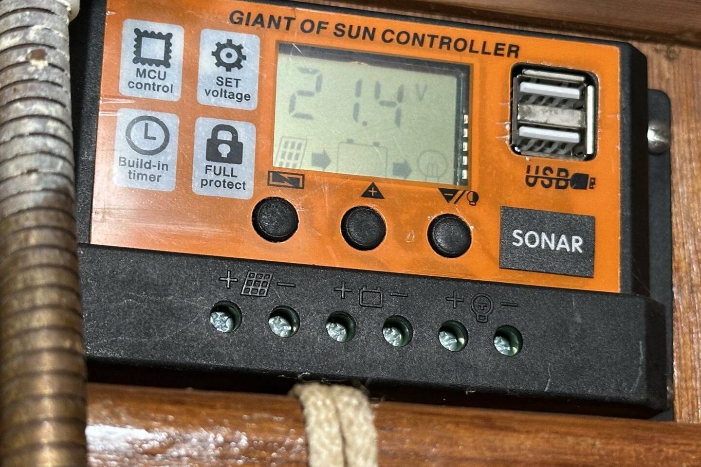 Orange solar controller with digital display, USB ports, and control buttons, model Hughes 3910, 1979.