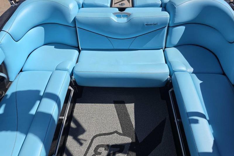 2017 MasterCraft X23 boat interior with blue seating and carpeted floor.