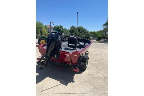 2025 Tracker Super Guide V-16 T boat, red, parked outdoors, rear view.