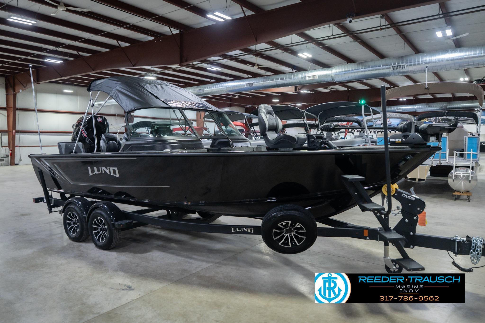 2026 Lund 2075 Impact XS boat in showroom, black exterior, on trailer.