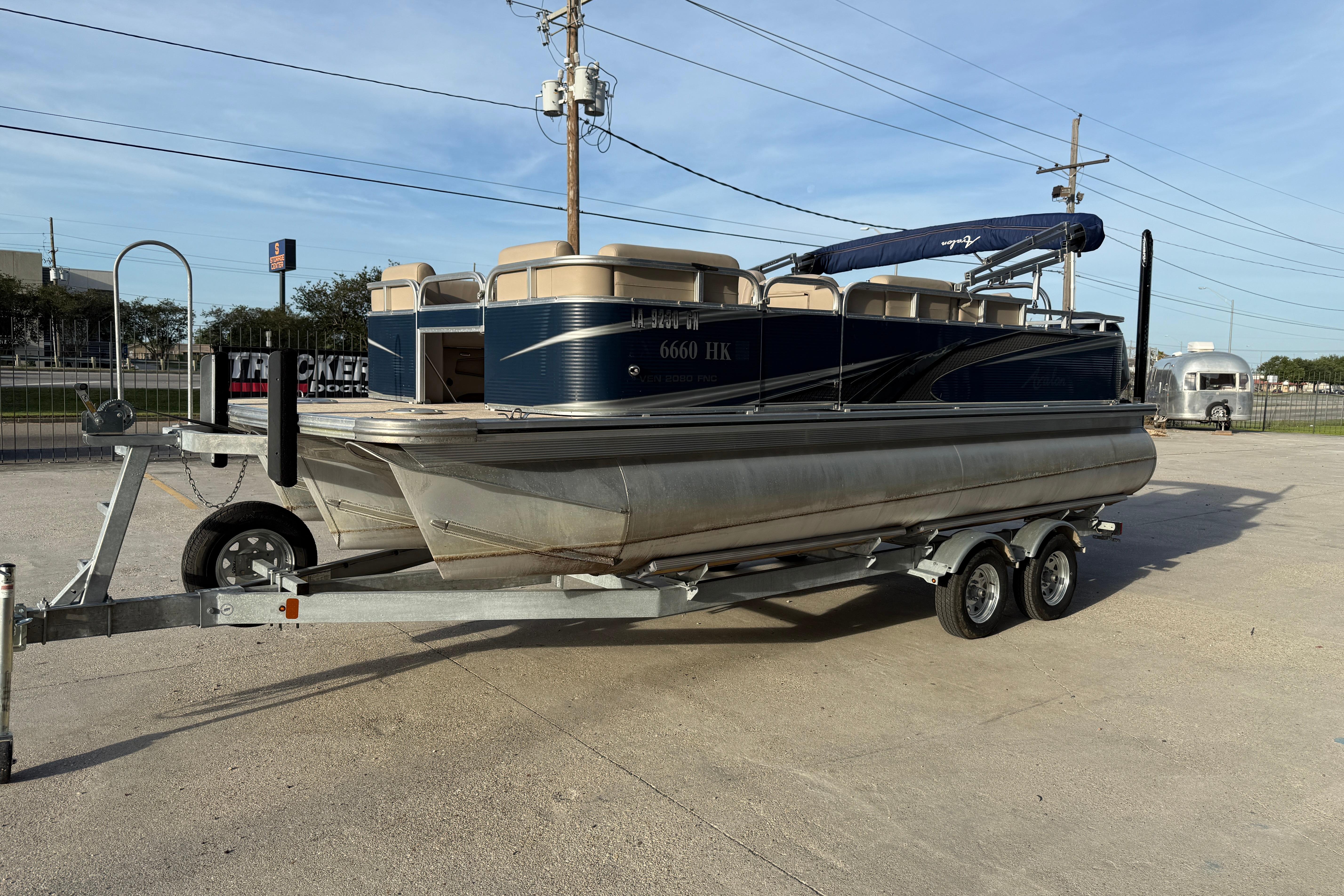 2019 Avalon Venture Fish N Cruise 20' pontoon boat on trailer in parking lot.