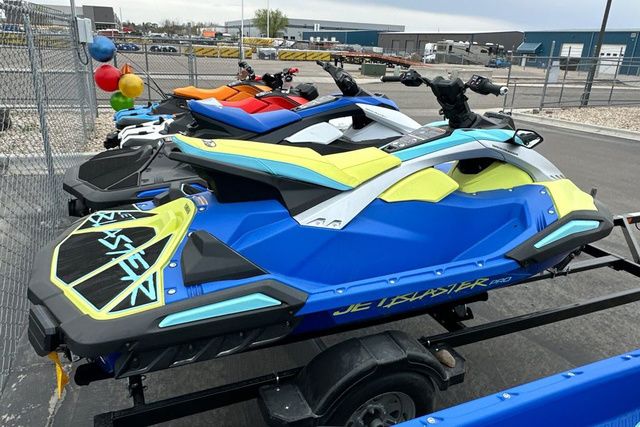 A blue and yellow Yamaha WaveRunner Jetblaster Pro on a trailer in a storage area.