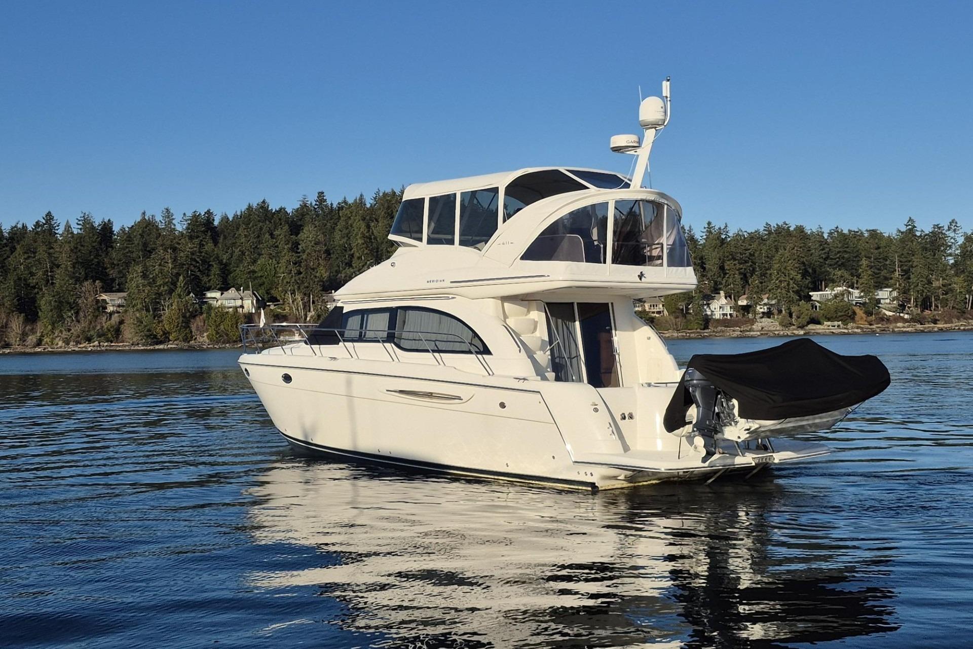2006 Meridian 411 Sedan yacht on calm water with forested shoreline background.
