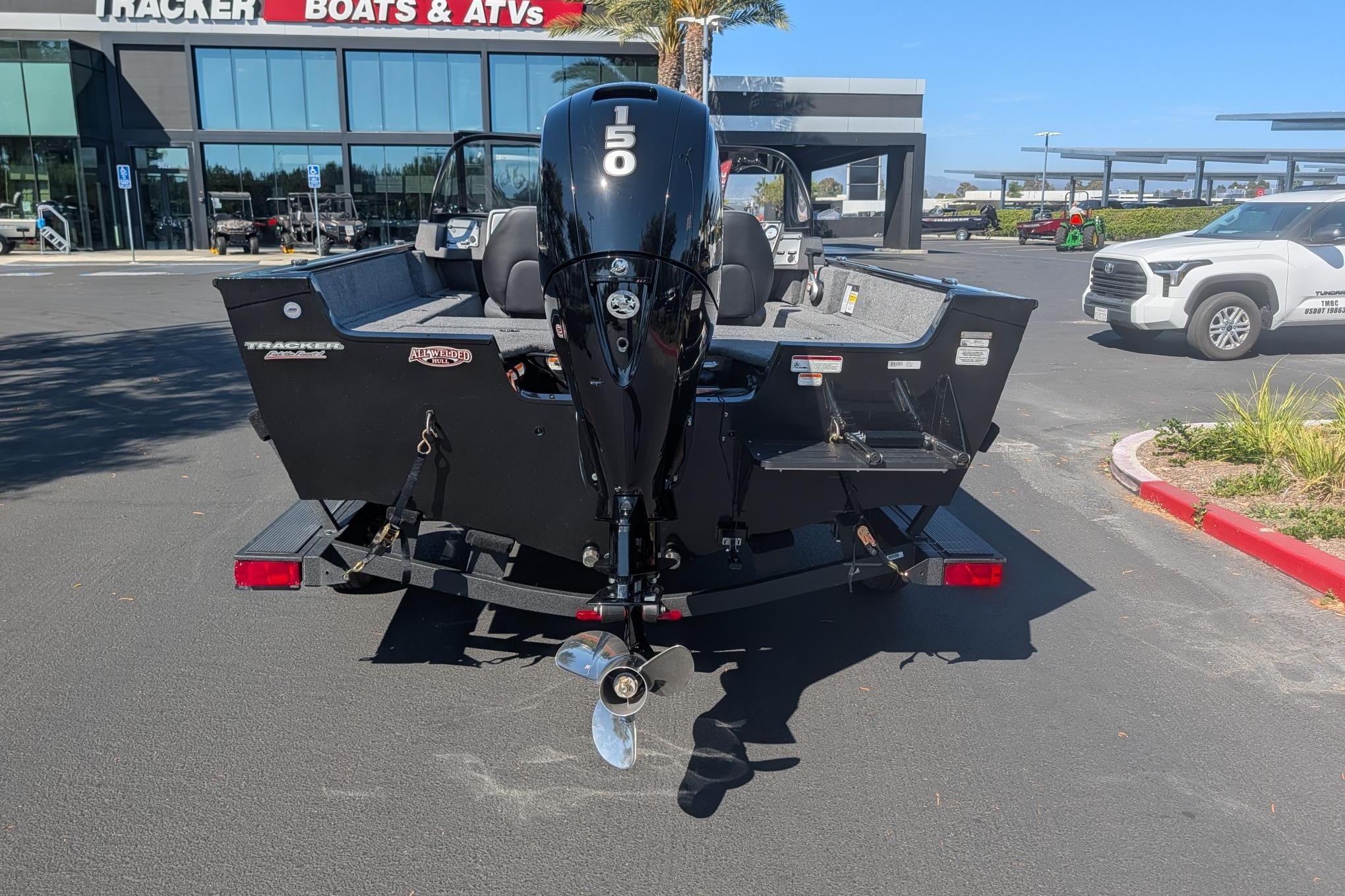 2026 Tracker Pro Guide V-175 Combo boat with 150 HP engine, parked outside dealership.