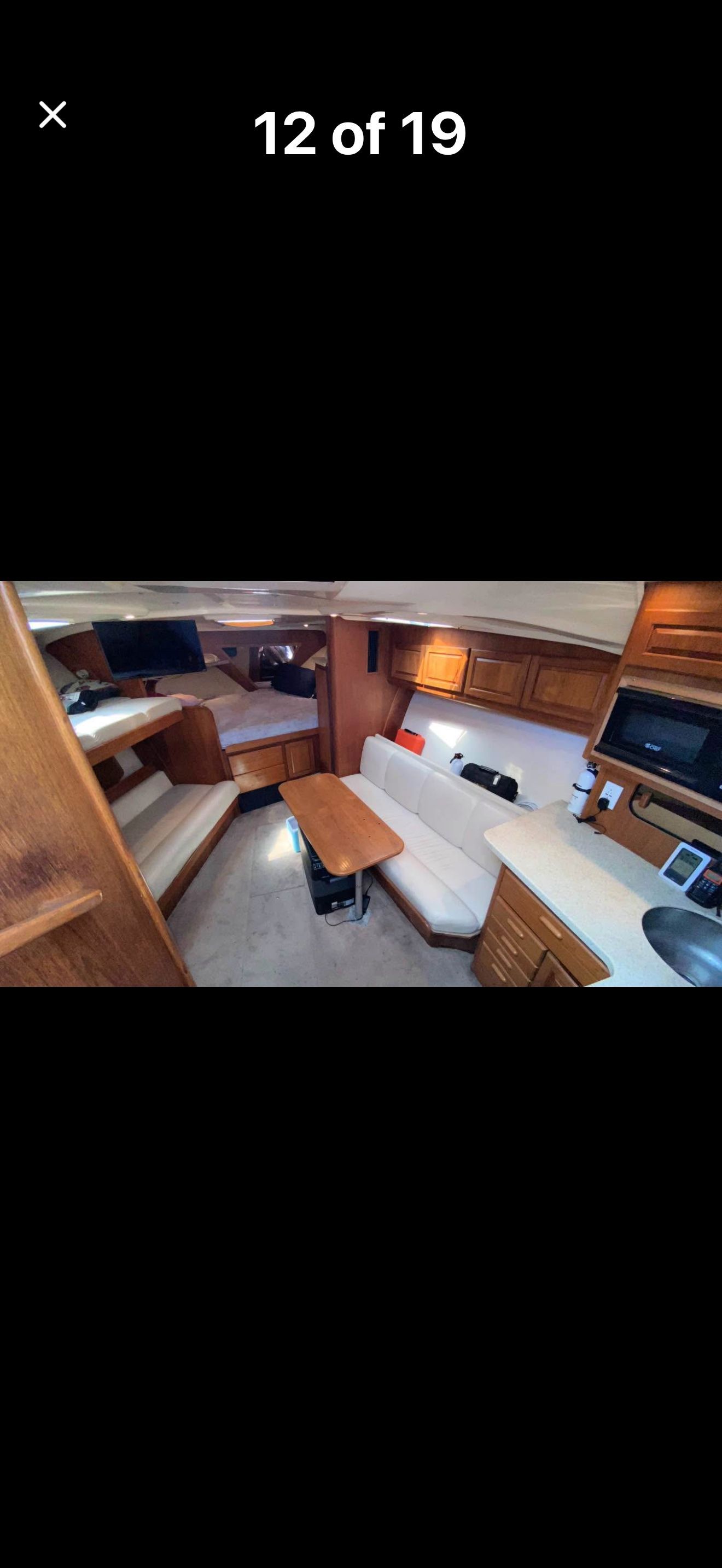 Interior of a 1999 Luhrs Sx36 with seating area and wooden cabinetry.