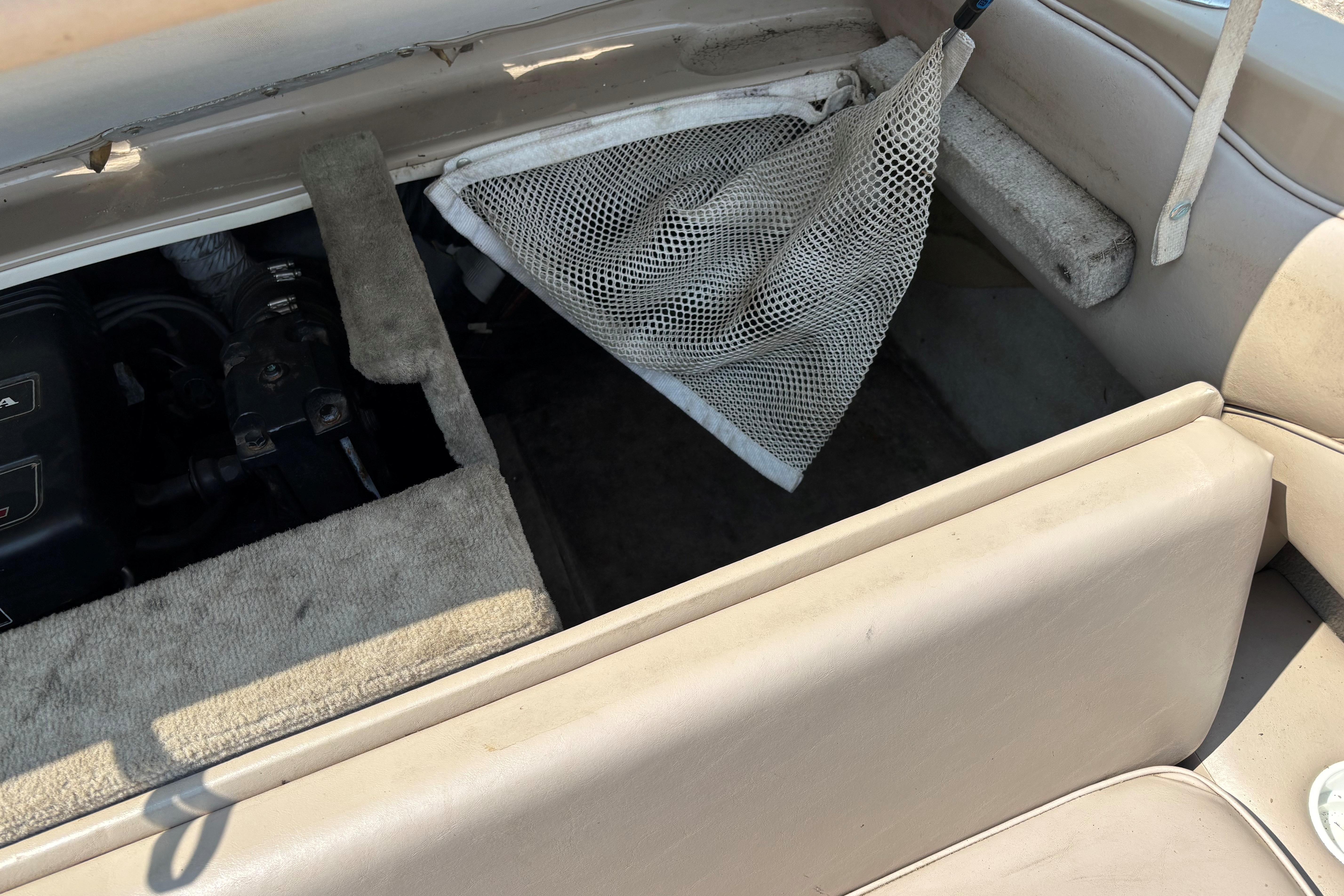 Open storage compartment in a 2001 Crownline 18' boat, showing interior details.