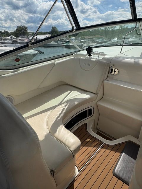 The image shows the cockpit of a 2005 Sea Ray Sundancer 280 with a beige seating area.