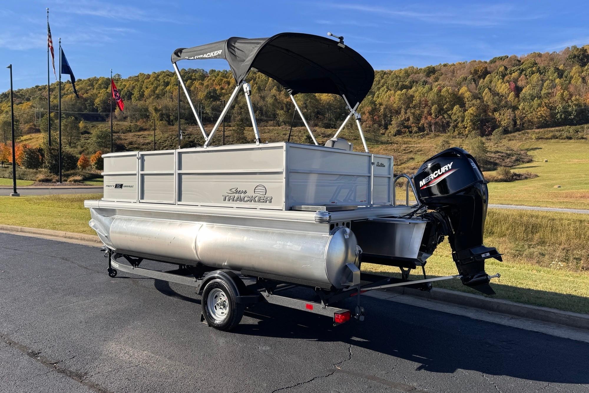 2026 Sun Tracker Party Barge 16 DLX pontoon boat on trailer, scenic background.