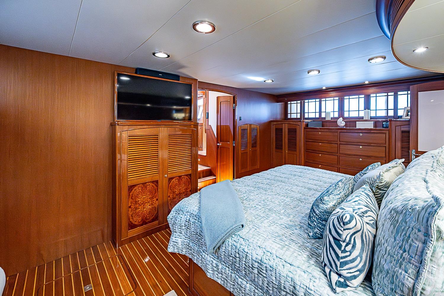 Luxurious bedroom interior of 2014 Marlow 80 Explorer yacht with elegant wood finishes.