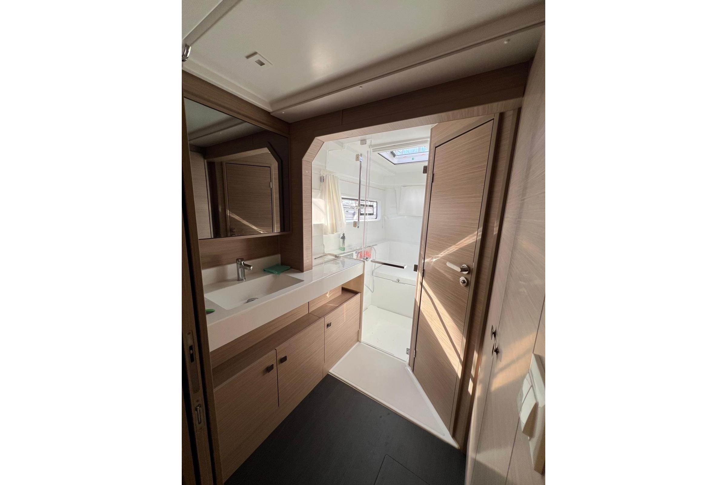 Modern bathroom interior of 2026 Lagoon 43 yacht, featuring sleek design and ample natural light.