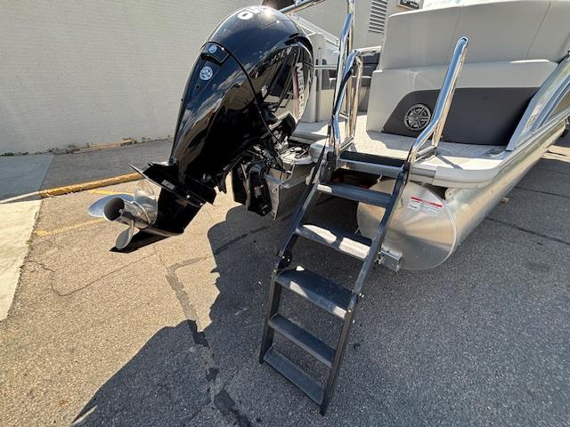 2025 Harris Cruiser 230 boat with outboard motor and boarding ladder.