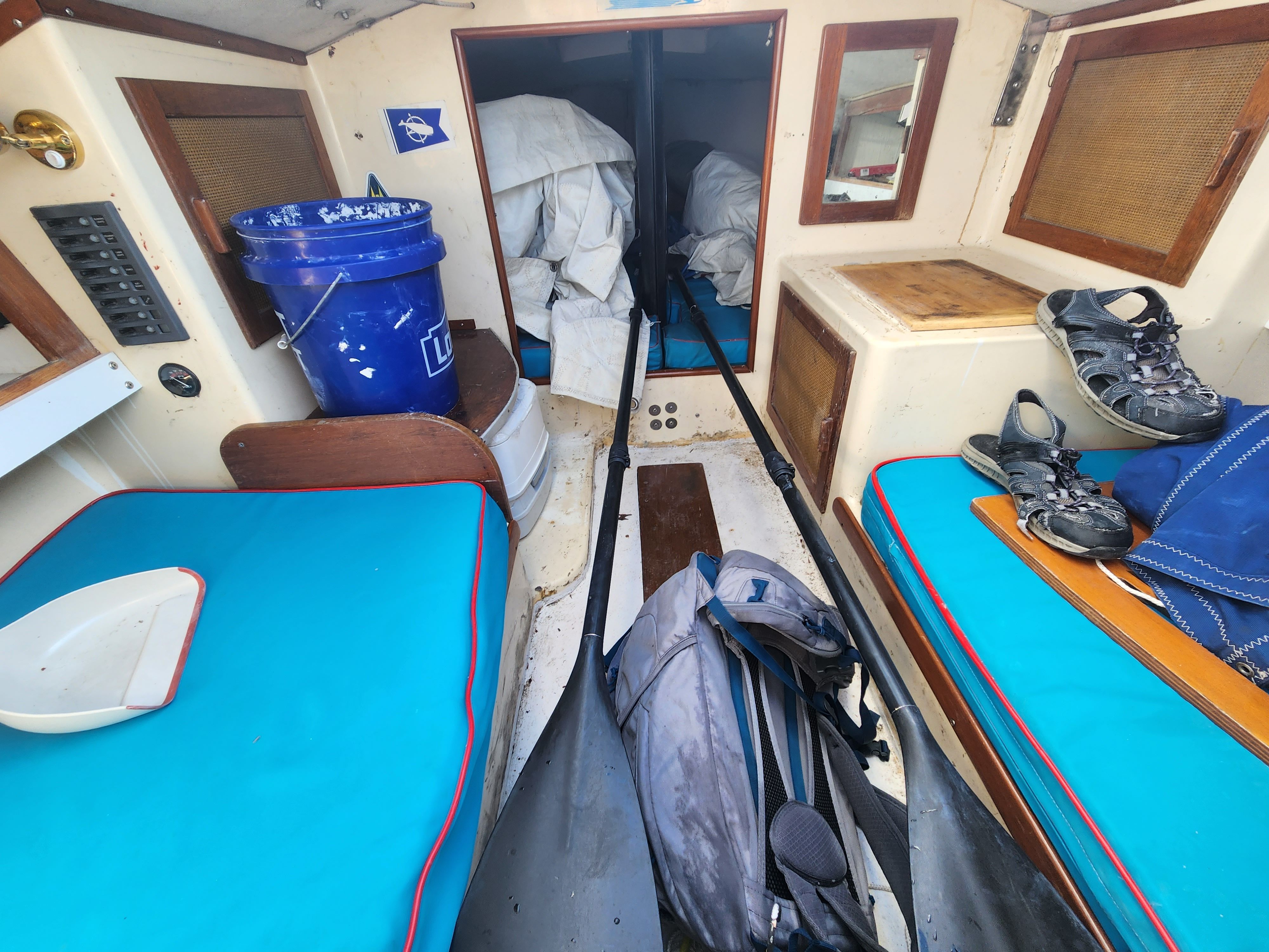Interior of a 1978 J Boats J/24 with blue cushions and gear.