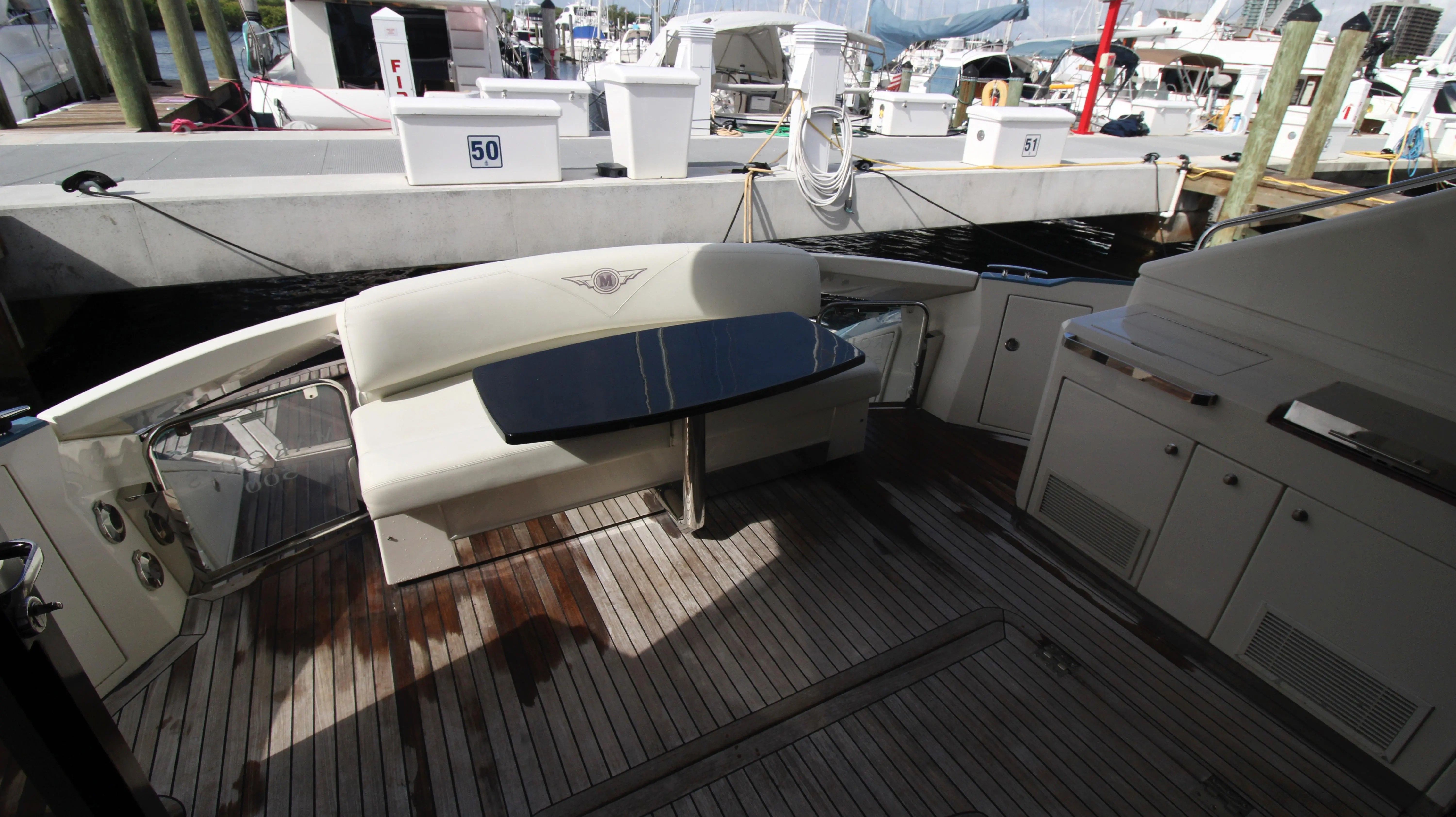 The image shows the stern of a 2010 Marquis Sport Coupe with a bench seat and table.