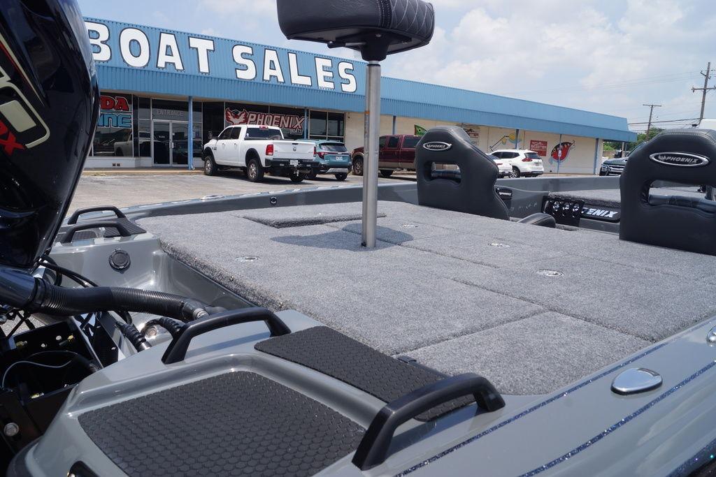 2027 Phoenix 921 Elite X II boat displayed at dealership, showcasing spacious deck and seating.