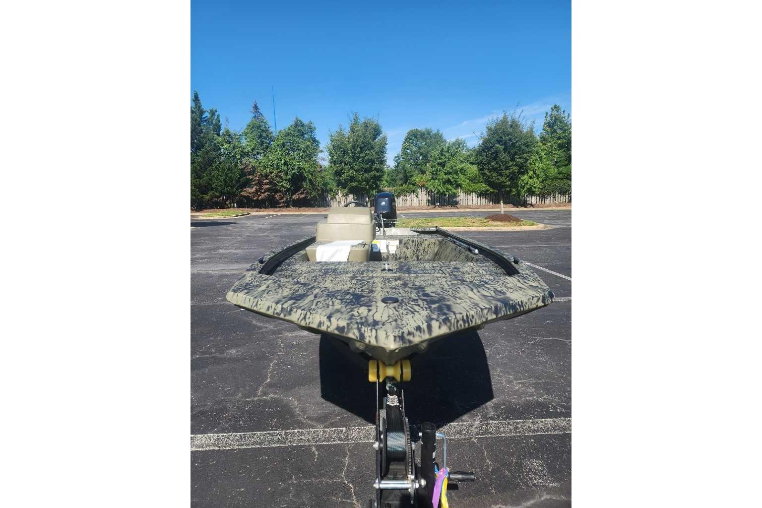2026 Tracker Grizzly 1648 SC boat in parking lot, camo design, clear sky.