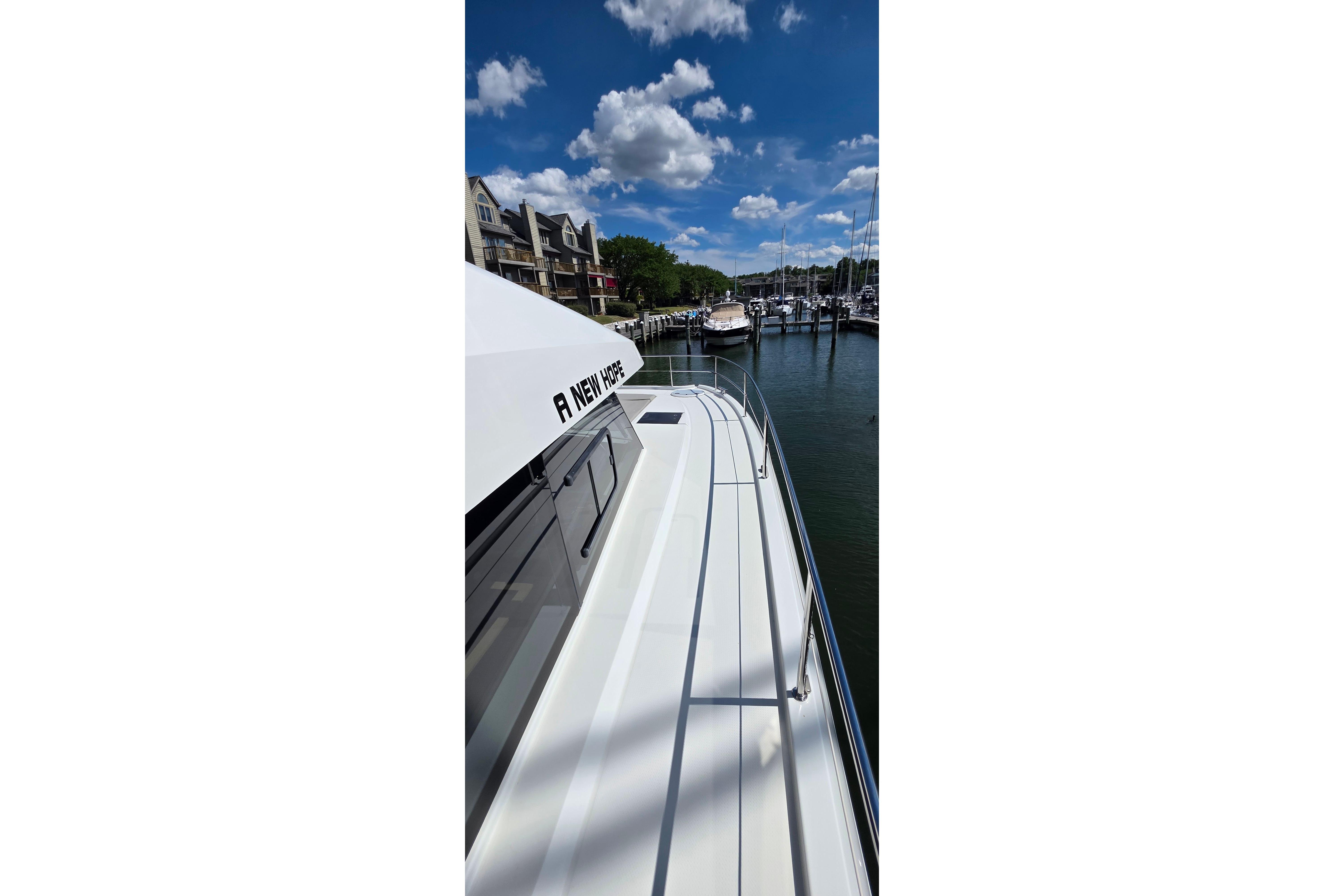 2018 Fountaine Pajot Motor Yacht 44 docked in a marina under a clear blue sky.