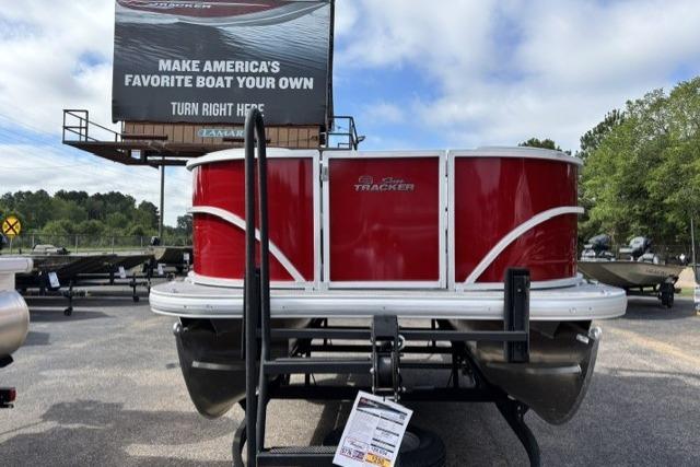 2026 Sun Tracker Party Barge 16 DLX pontoon boat on trailer, with promotional billboard.
