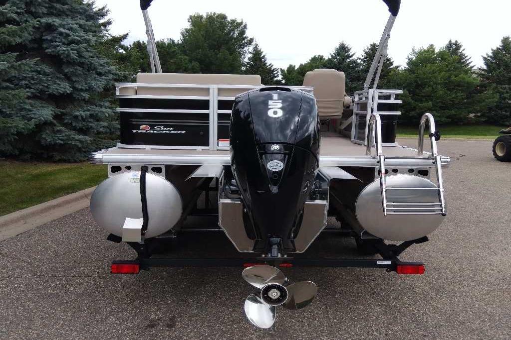 2025 Sun Tracker Sportfish 24 XP3 pontoon boat with powerful outboard motor, parked outdoors.