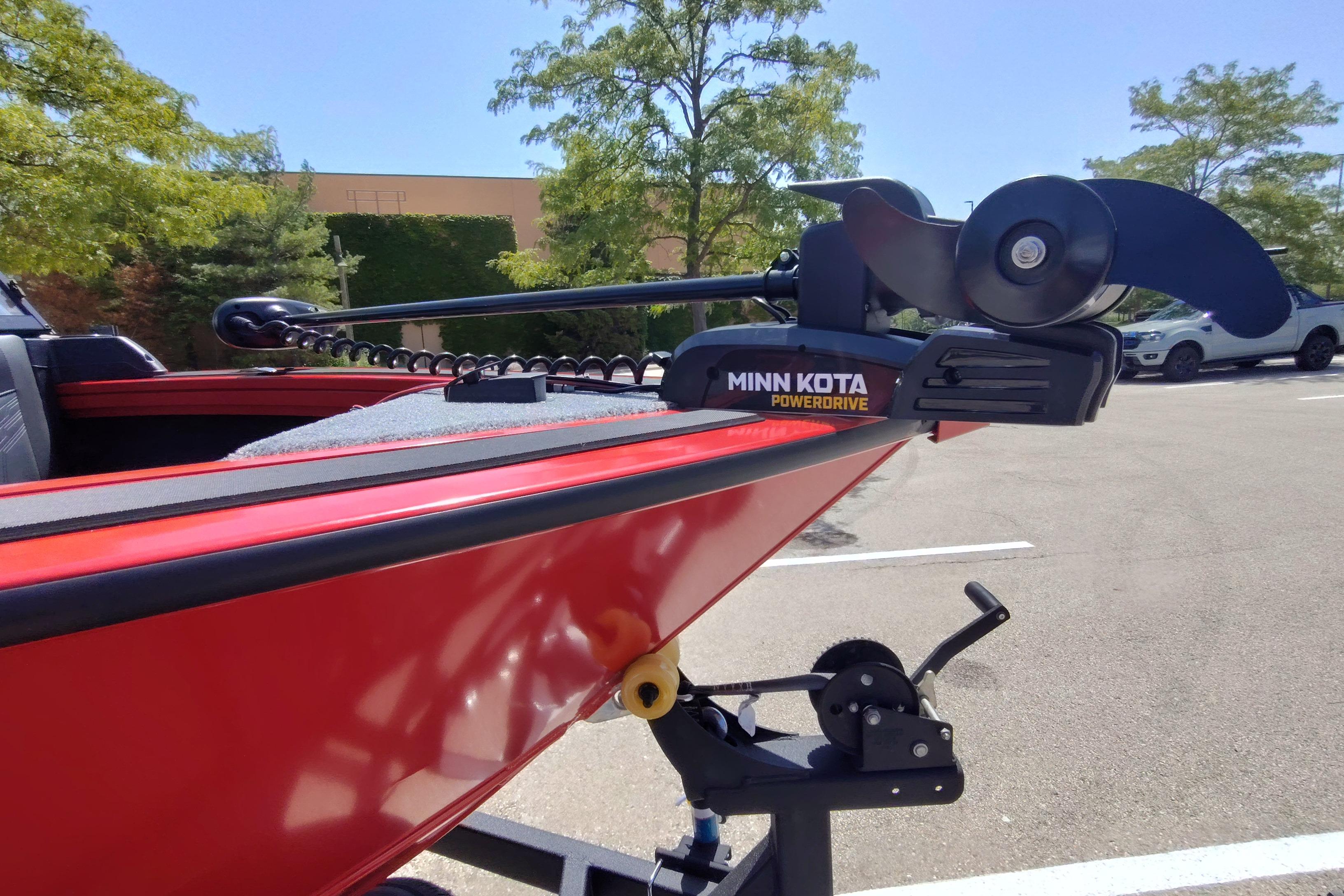 Red 2026 Tracker Targa V-18 Combo boat with Minn Kota PowerDrive motor in parking lot.
