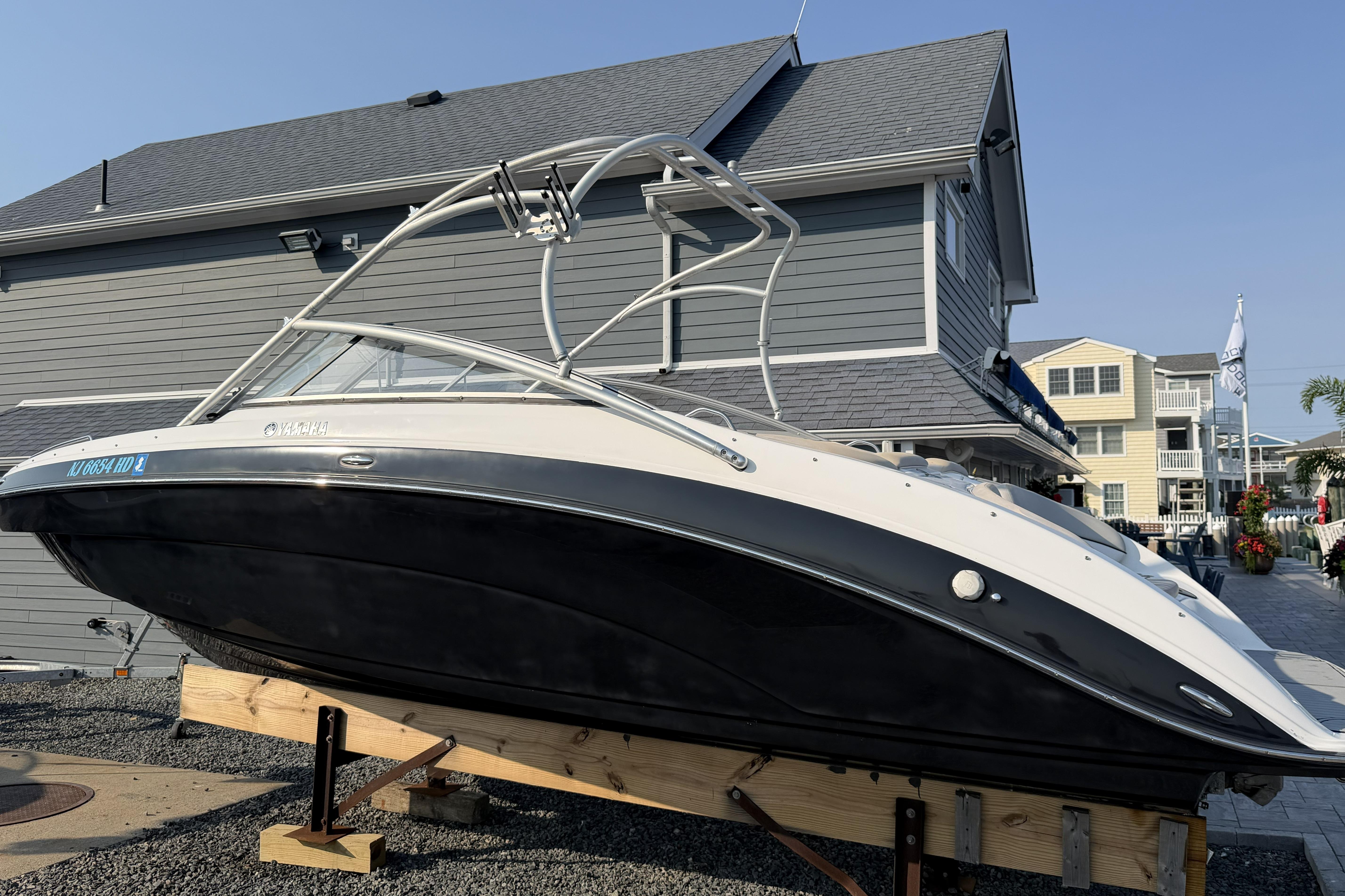 2011 Yamaha Boats AR240 HO displayed on wooden supports near a house.