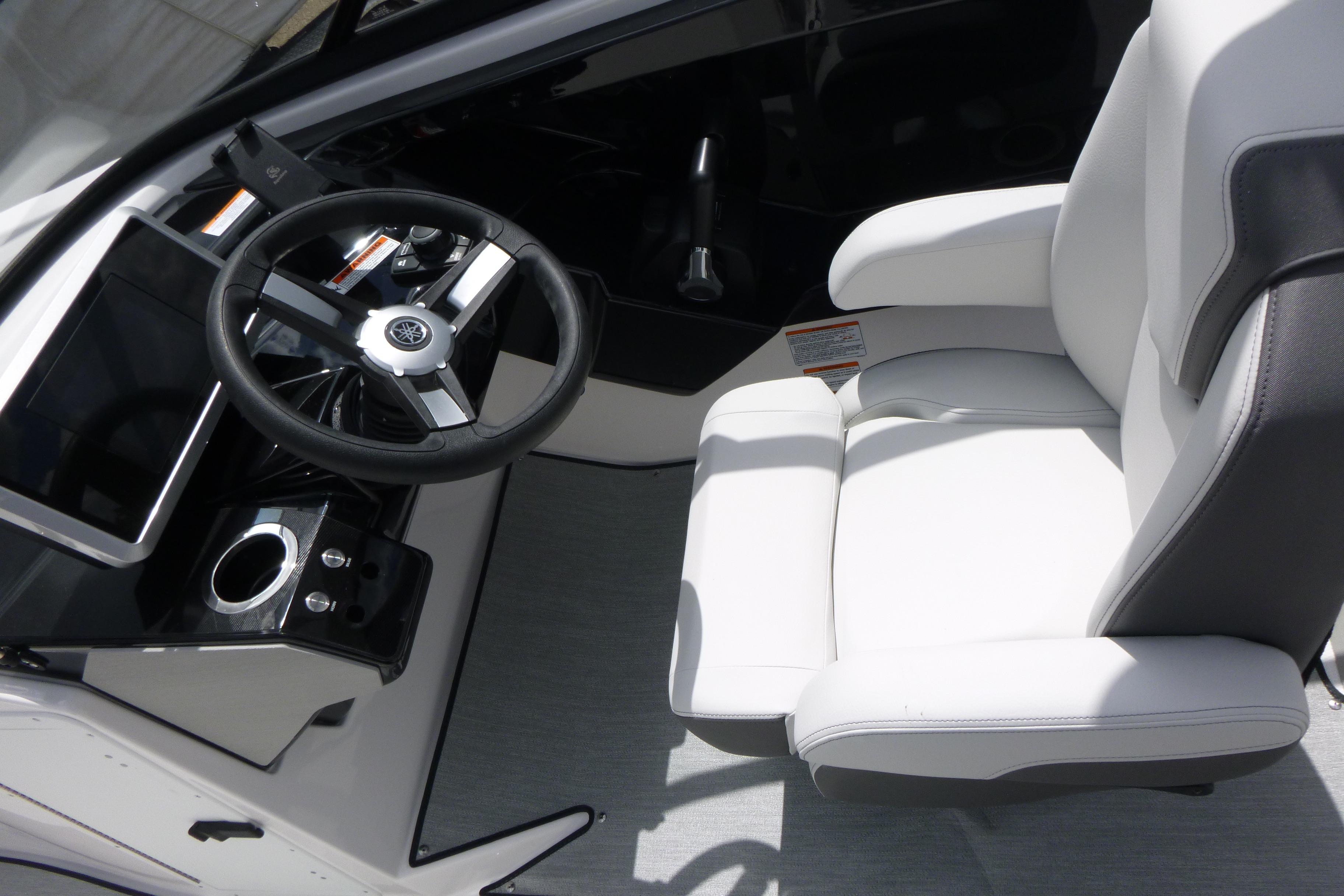 2026 Yamaha Boats AR250 cockpit with steering wheel and white captain's chair.