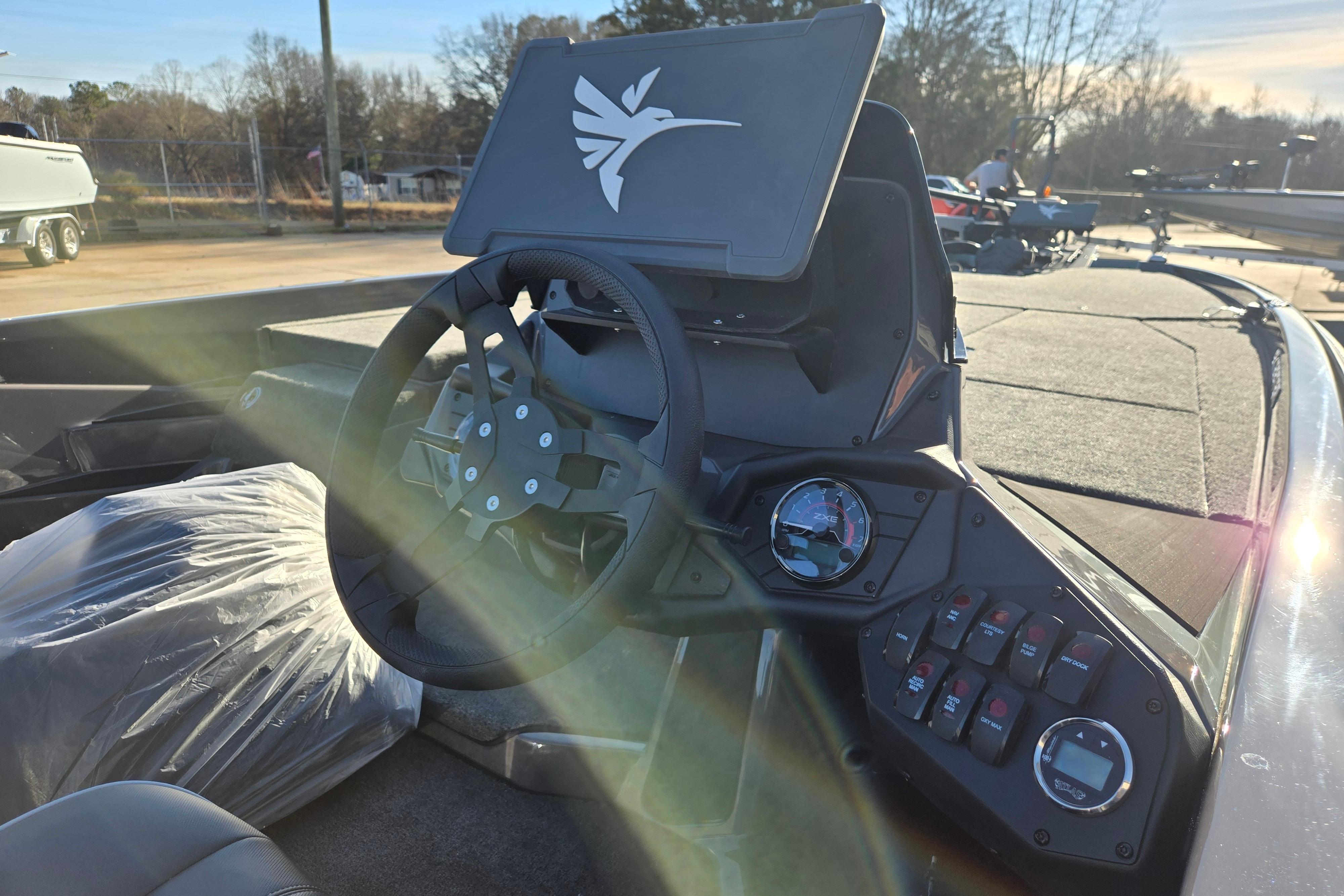 2026 Skeeter ZXE21 boat dashboard with steering wheel and control panel in sunlight.