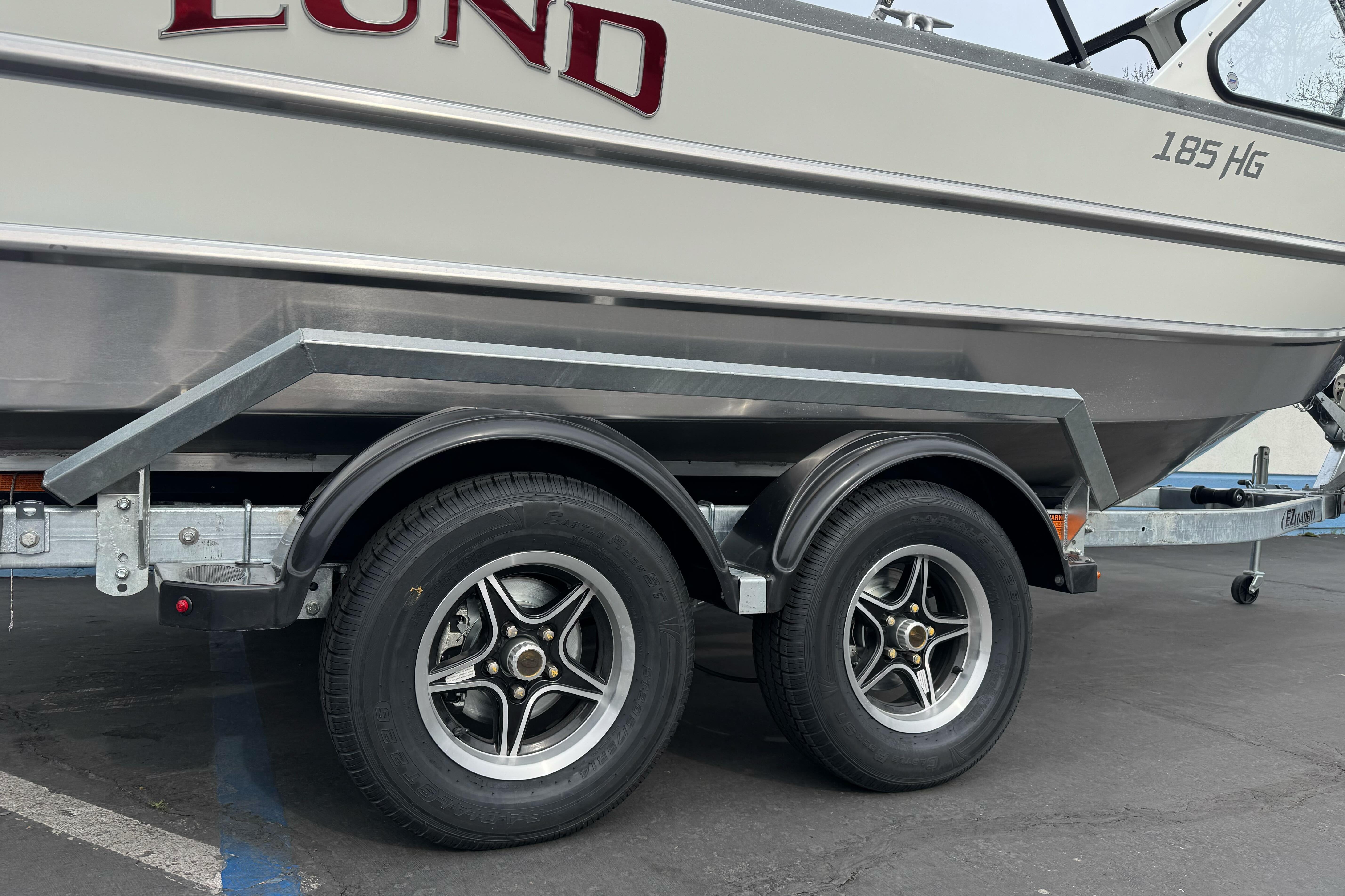 2026 Lund 185 Heavy Gauge boat on a dual-axle trailer, side view.