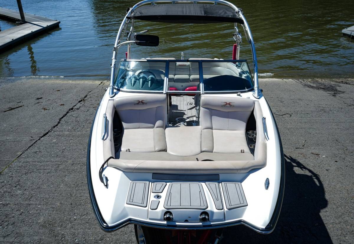 A 2007 MasterCraft X-45 boat at a dock. It features white upholstery and a modern design.