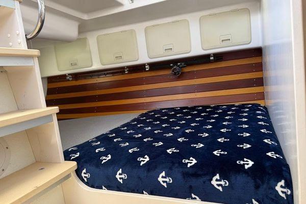 Cozy cabin interior of 2011 Reliance 44 with anchor-patterned bedding.