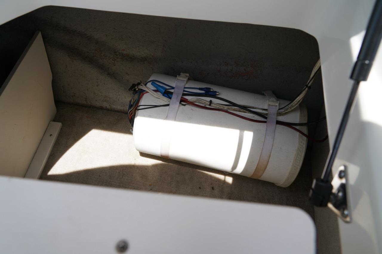 Storage compartment in a 2004 Crownline 216 LS boat with secured equipment.