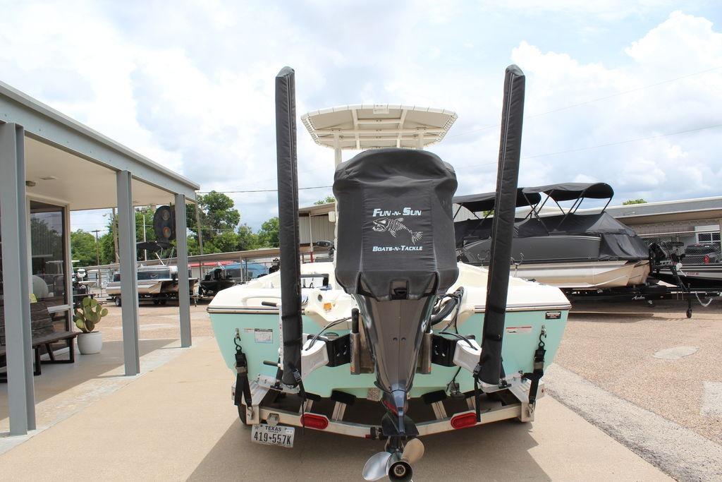 2026 Skeeter SX230 boat with motor cover, parked at a dealership under a cloudy sky.