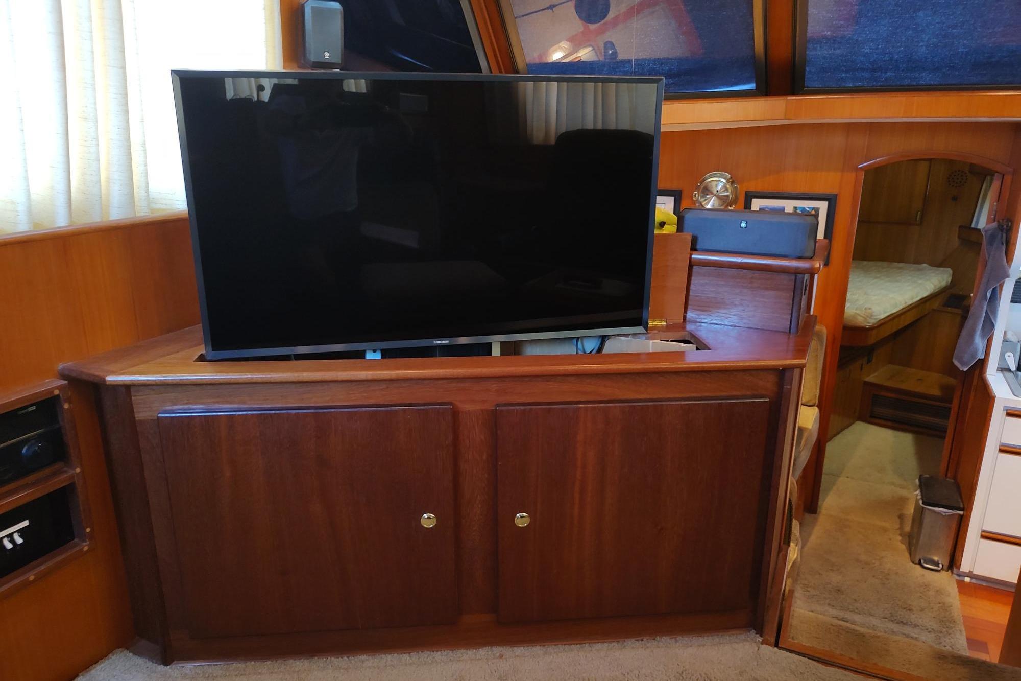 Interior of 1989 Hyatt Double Cabin Motoryacht with TV and wooden cabinetry.