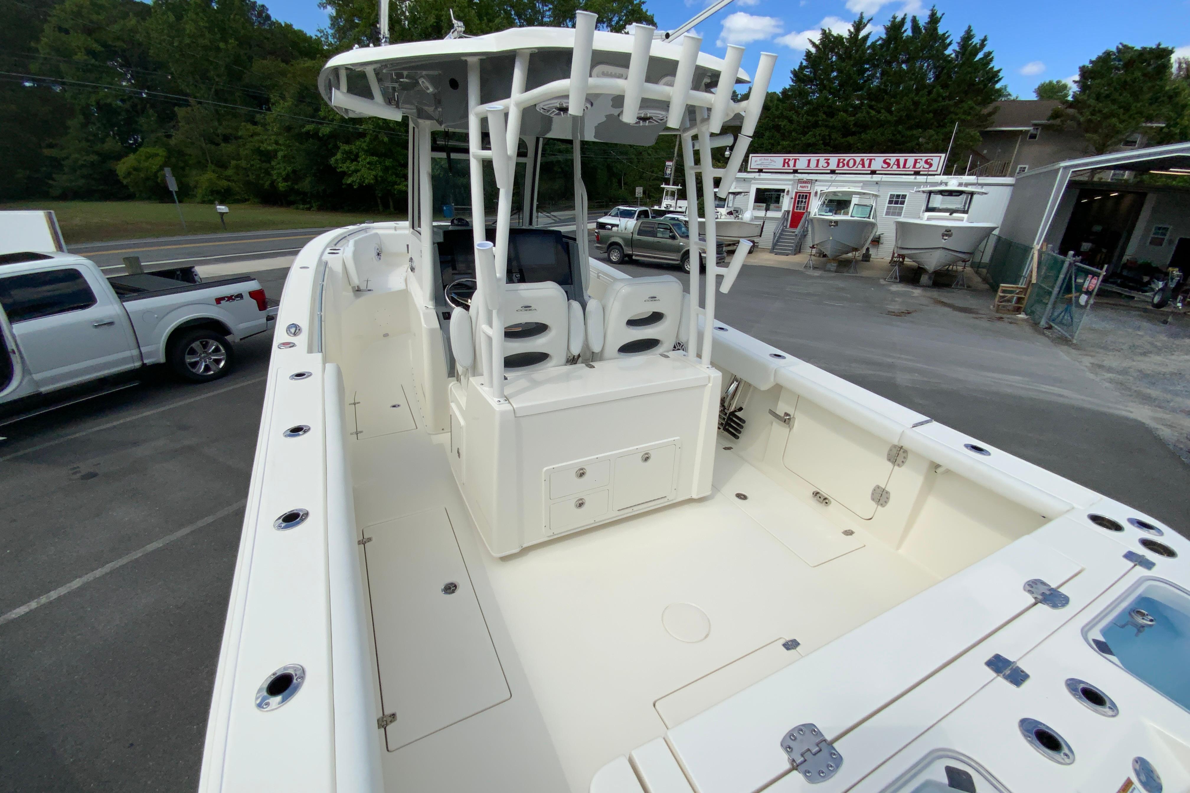 2027 Cobia 320 Center Console boat at dealership, showcasing spacious deck and seating.